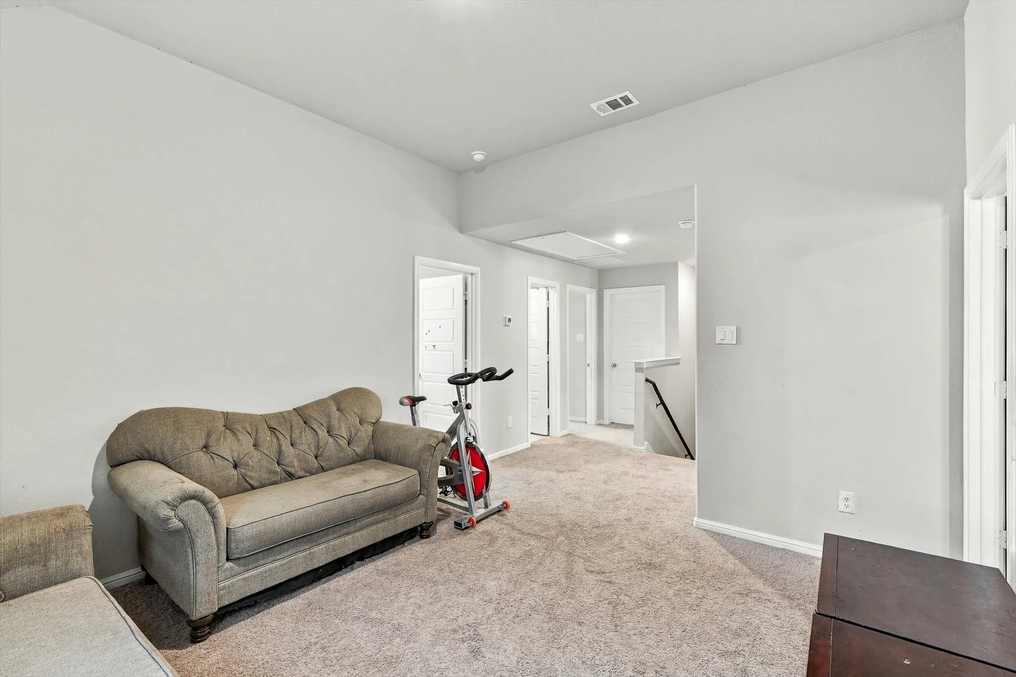 Carpeted flooring, vaulted ceiling, white walls, and white trim