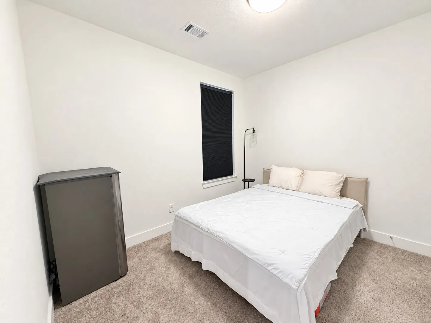 Clean white walls, neutral carpet flooring, recessed window, and white trim