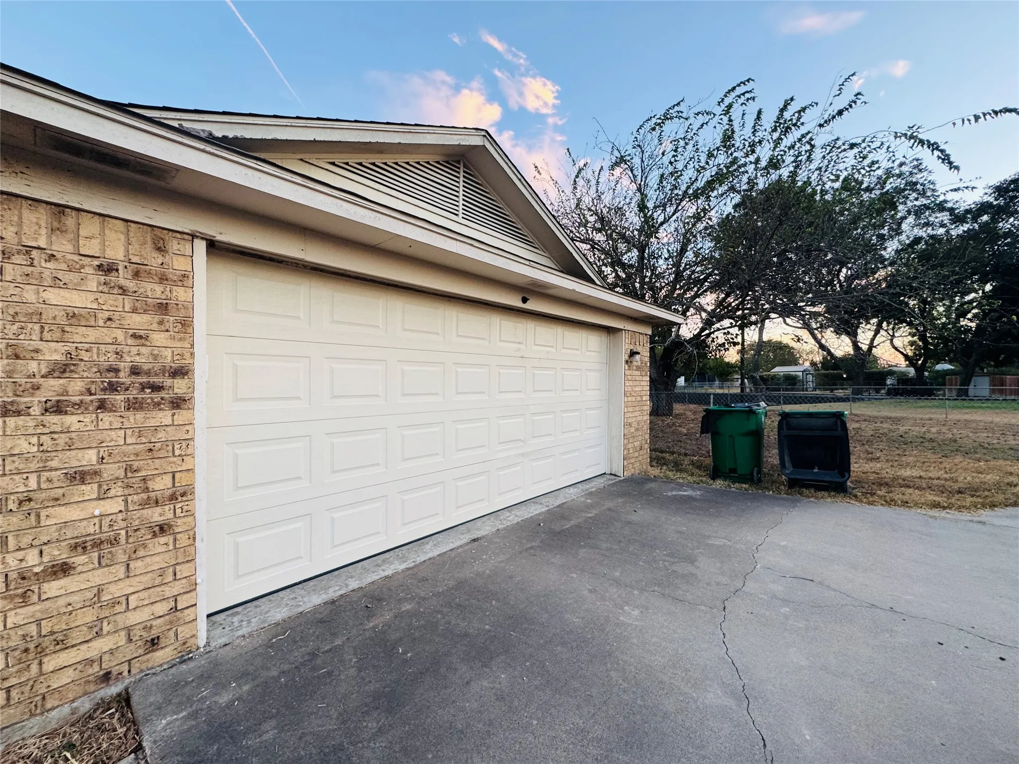 Brick exterior with a paneled garage door and a concrete driveway