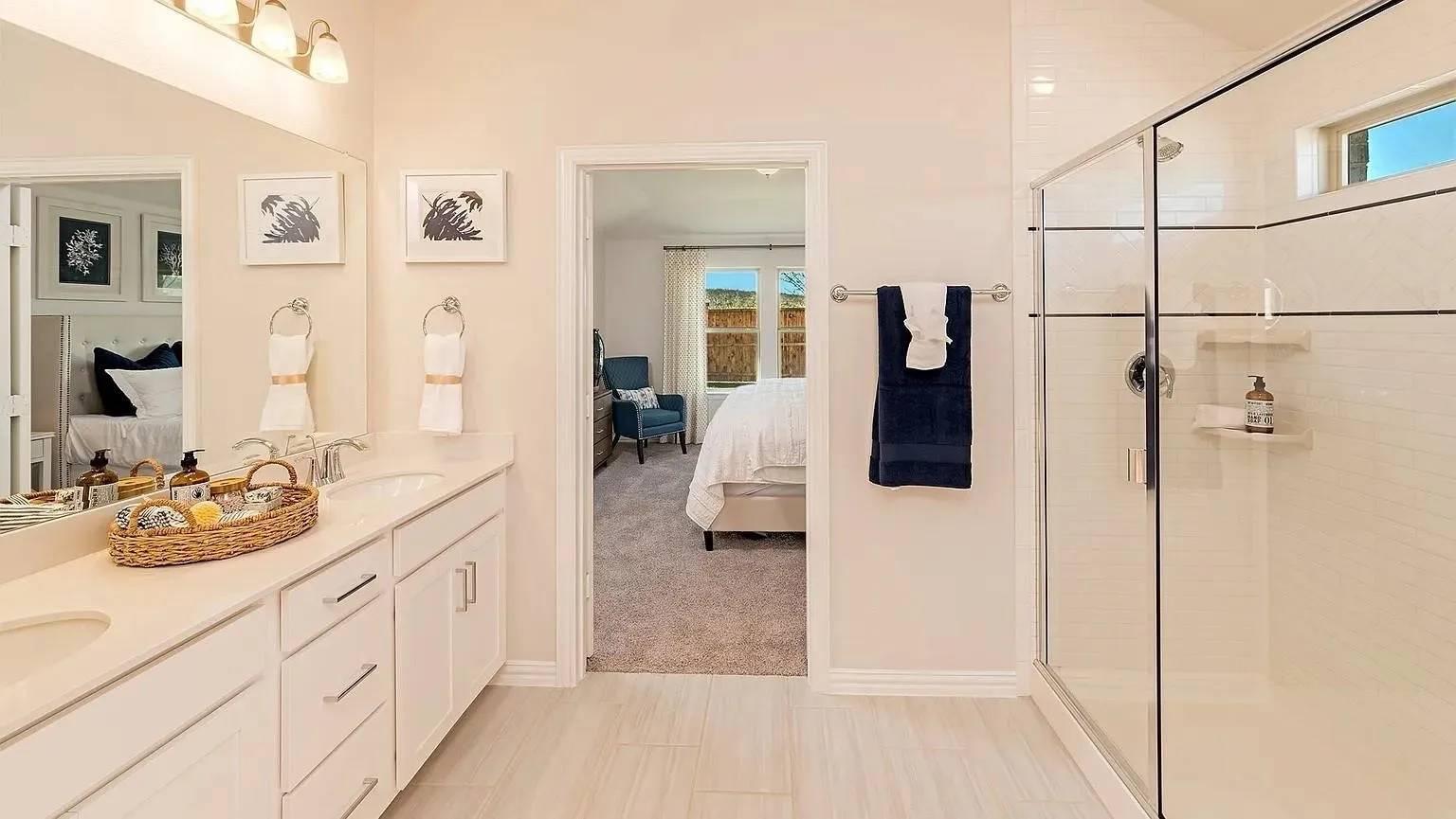 Dual vanity with undermount sinks, frameless glass shower enclosure, and tiled shower walls