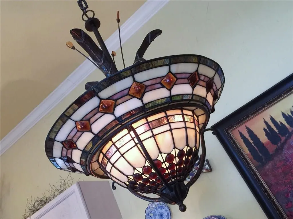 Stained glass chandelier with decorative metal accents and crown molding