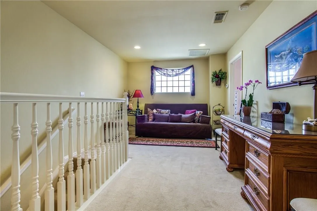 Carpeted landing with white painted balusters and railings
