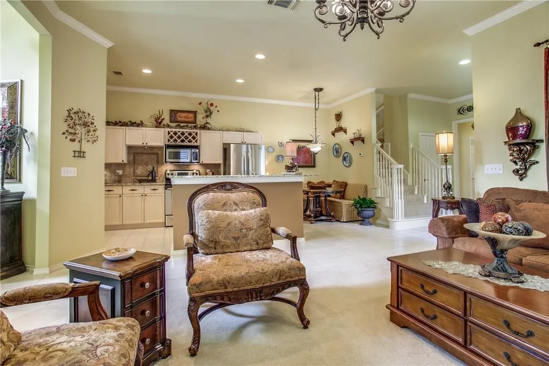 Open-concept living area with tray ceiling, recessed lighting, and tile flooring