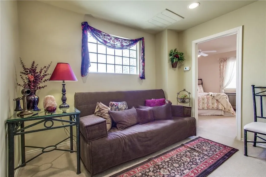 Recessed ceiling lighting, window with grid pattern, neutral wall color, carpeted flooring, and permanent doorway
