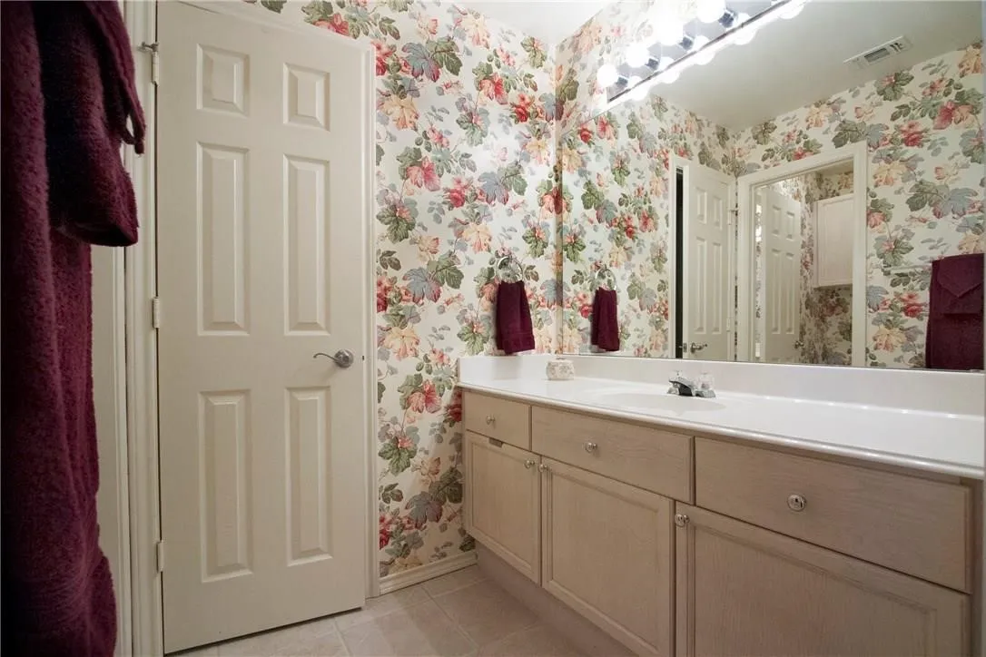 Expansive vanity with a single basin sink, integrated countertop, and ample storage cabinetry