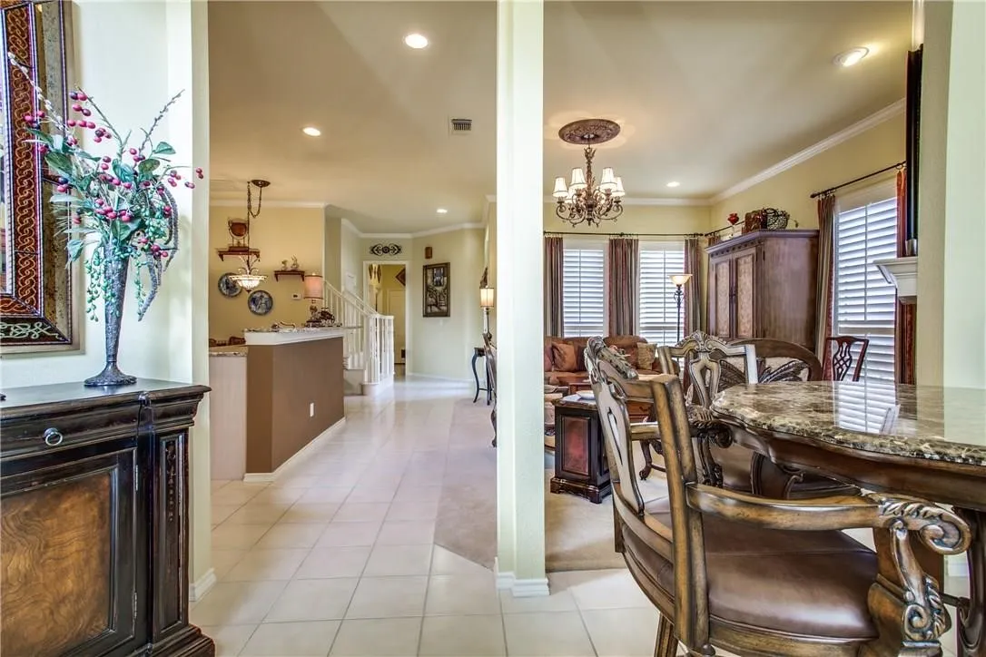 Tile flooring, recessed lighting, crown molding, chandelier, and built-in bar
