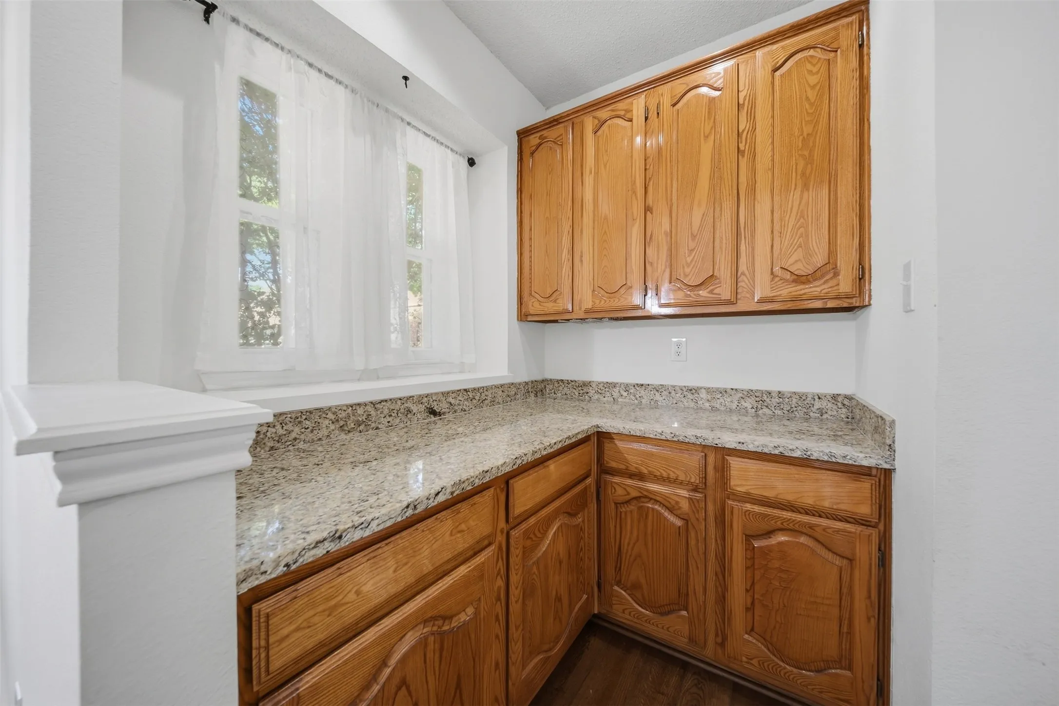 Wood-finish cabinetry, extensive counter space, and a built-in window