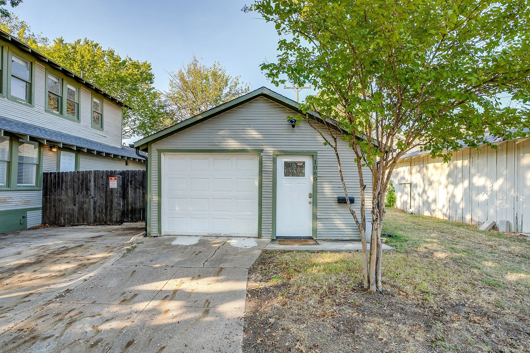 Detached garage with a roll-up door, a separate pedestrian entry, and horizontal siding