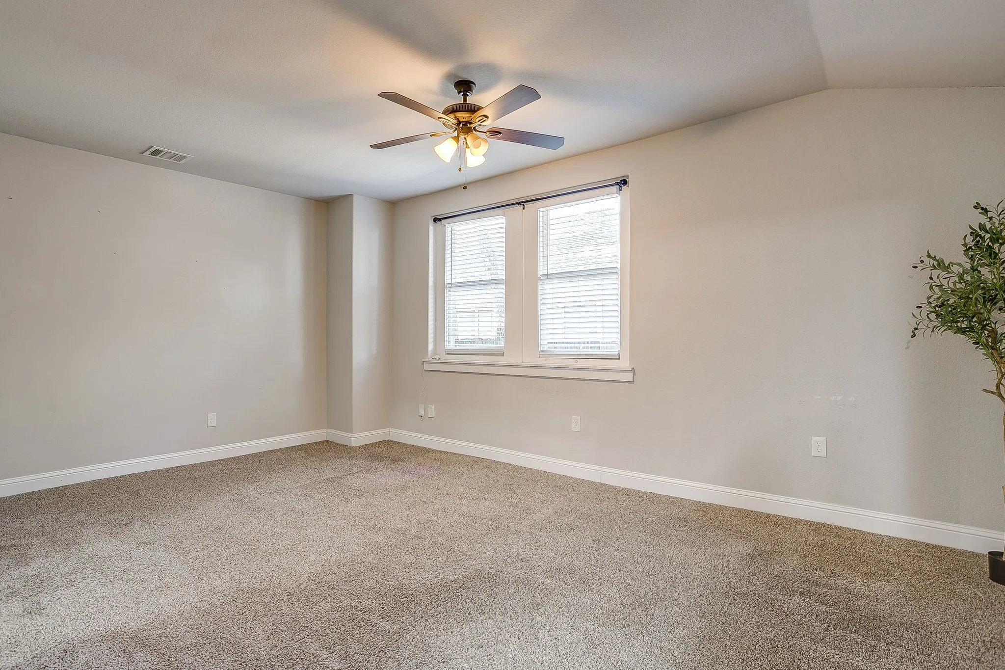 Neutral tone wall paint with white trim, double windows with blinds, and a ceiling fan with integrated lighting