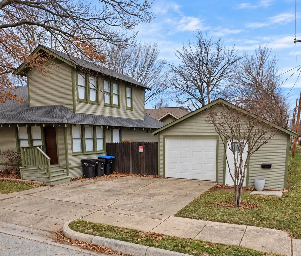Two-story exterior with horizontal siding, a gabled roof, and a detached single-car garage