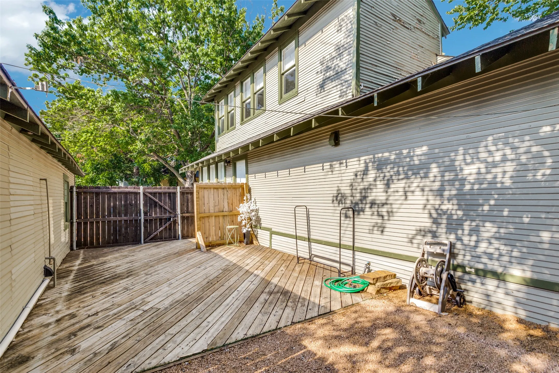 Expansive wood-plank deck with a wood privacy fence and gravel ground cover
