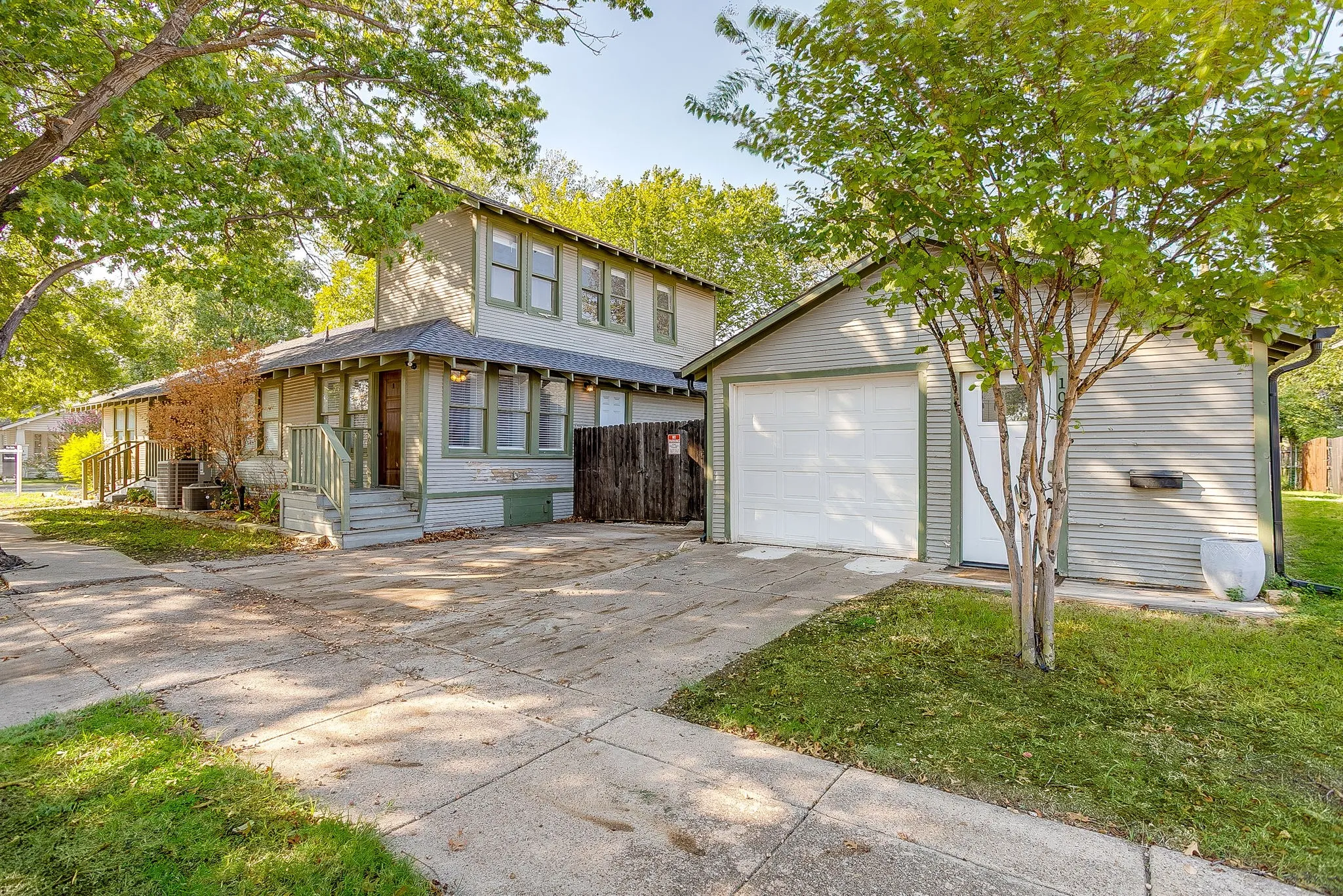 Two-story residence with a covered porch, an attached garage, and a concrete driveway