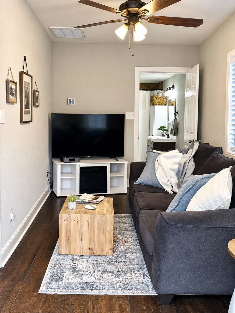 Wood-finish flooring, ceiling fan with integrated lighting, and white trim throughout