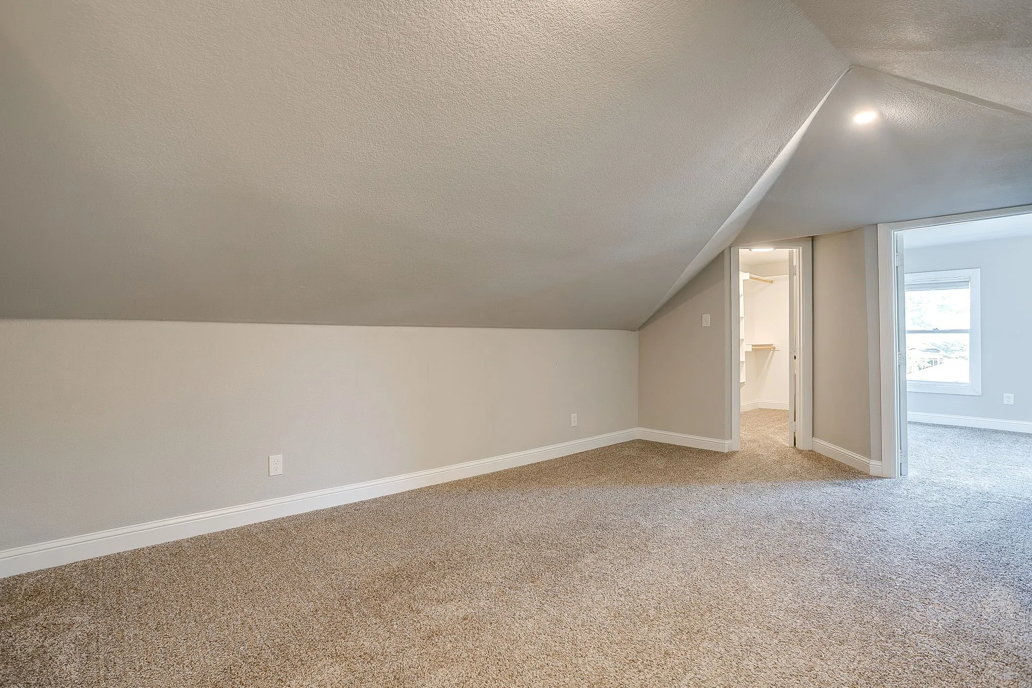 Carpeted room featuring a sloped ceiling and recessed lighting