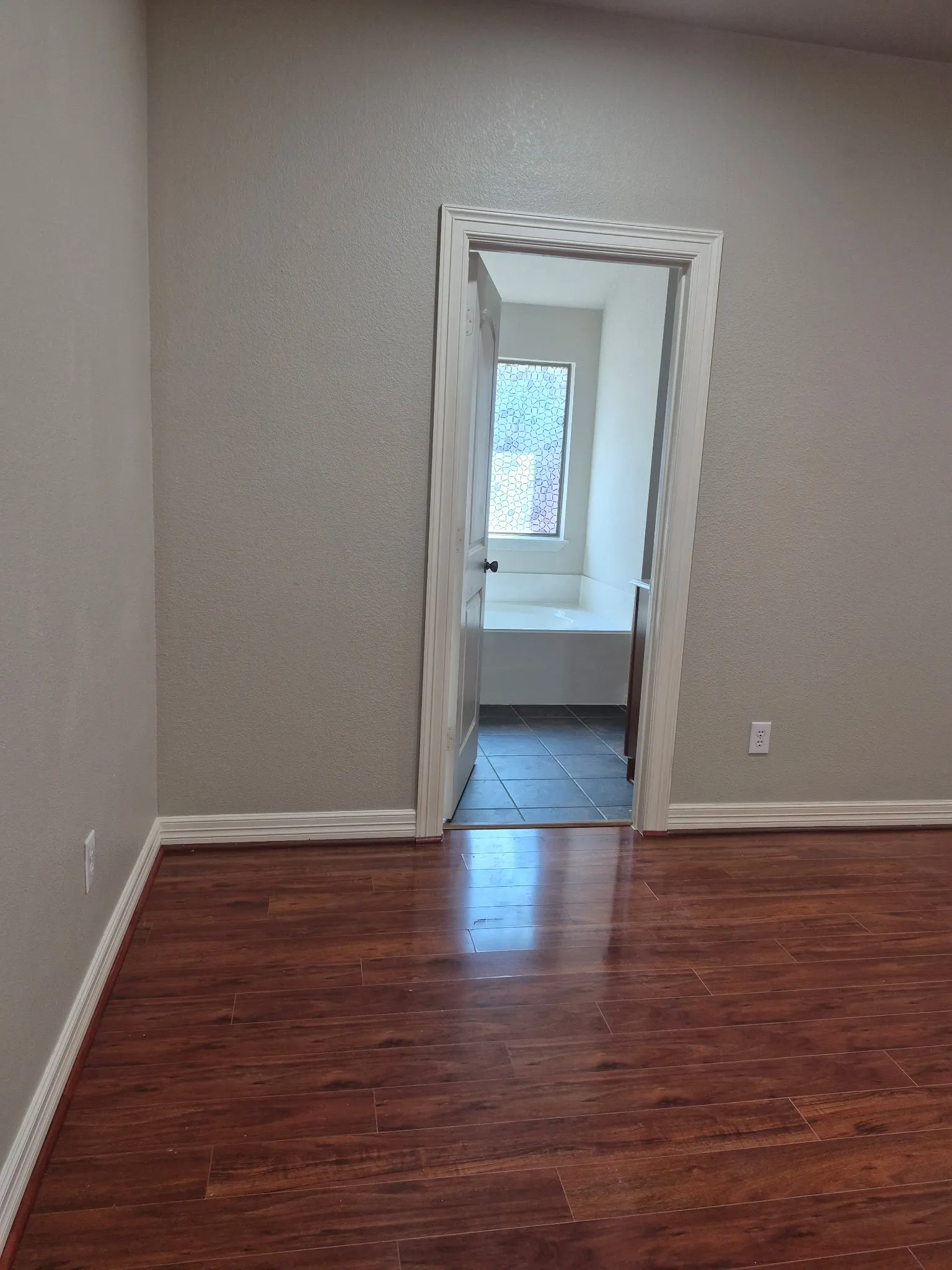 Wood-finish flooring with white trim and neutral wall tones