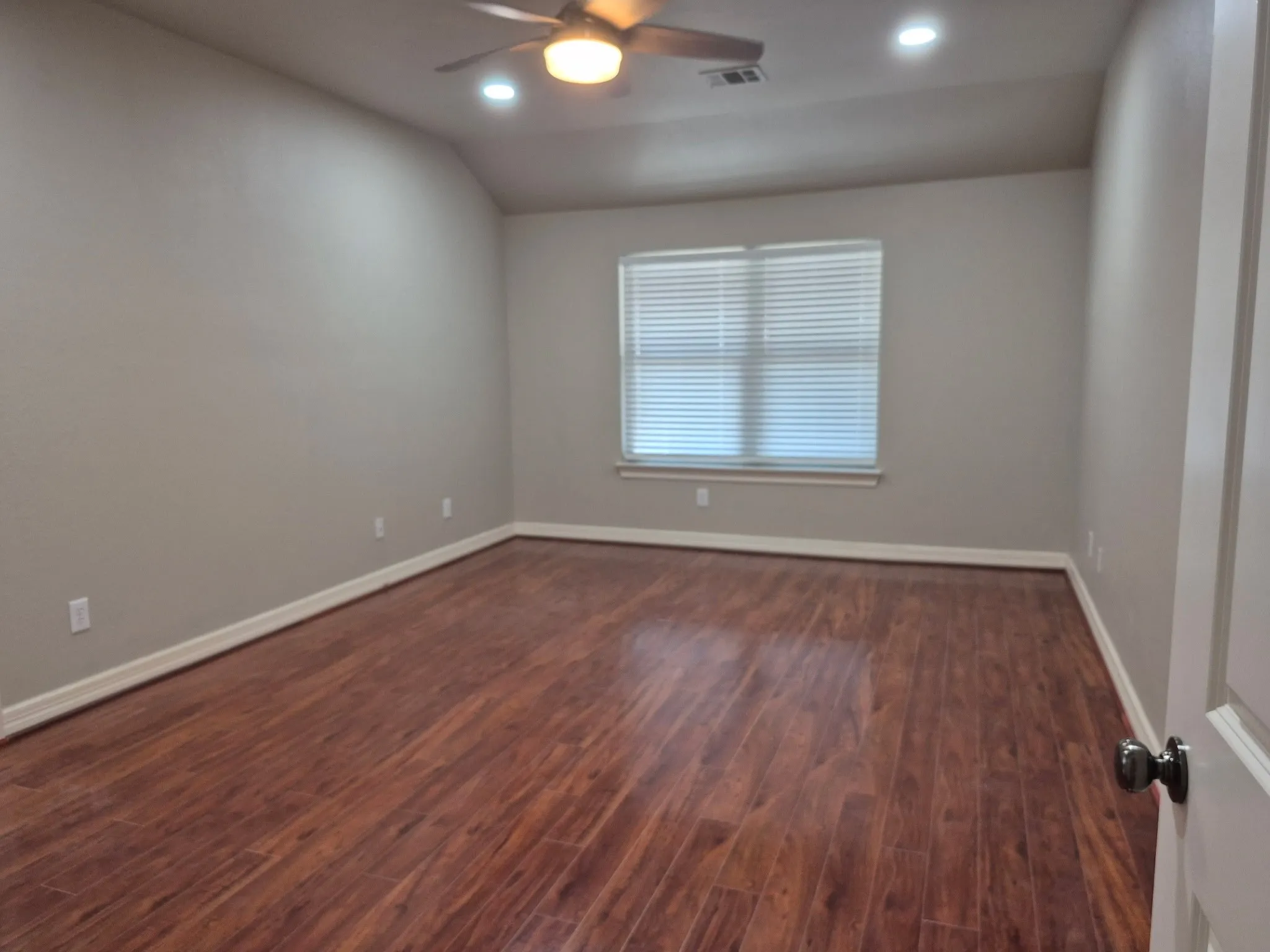 Vaulted ceiling with a ceiling fan, recessed lighting, wood-finish flooring, and window blinds