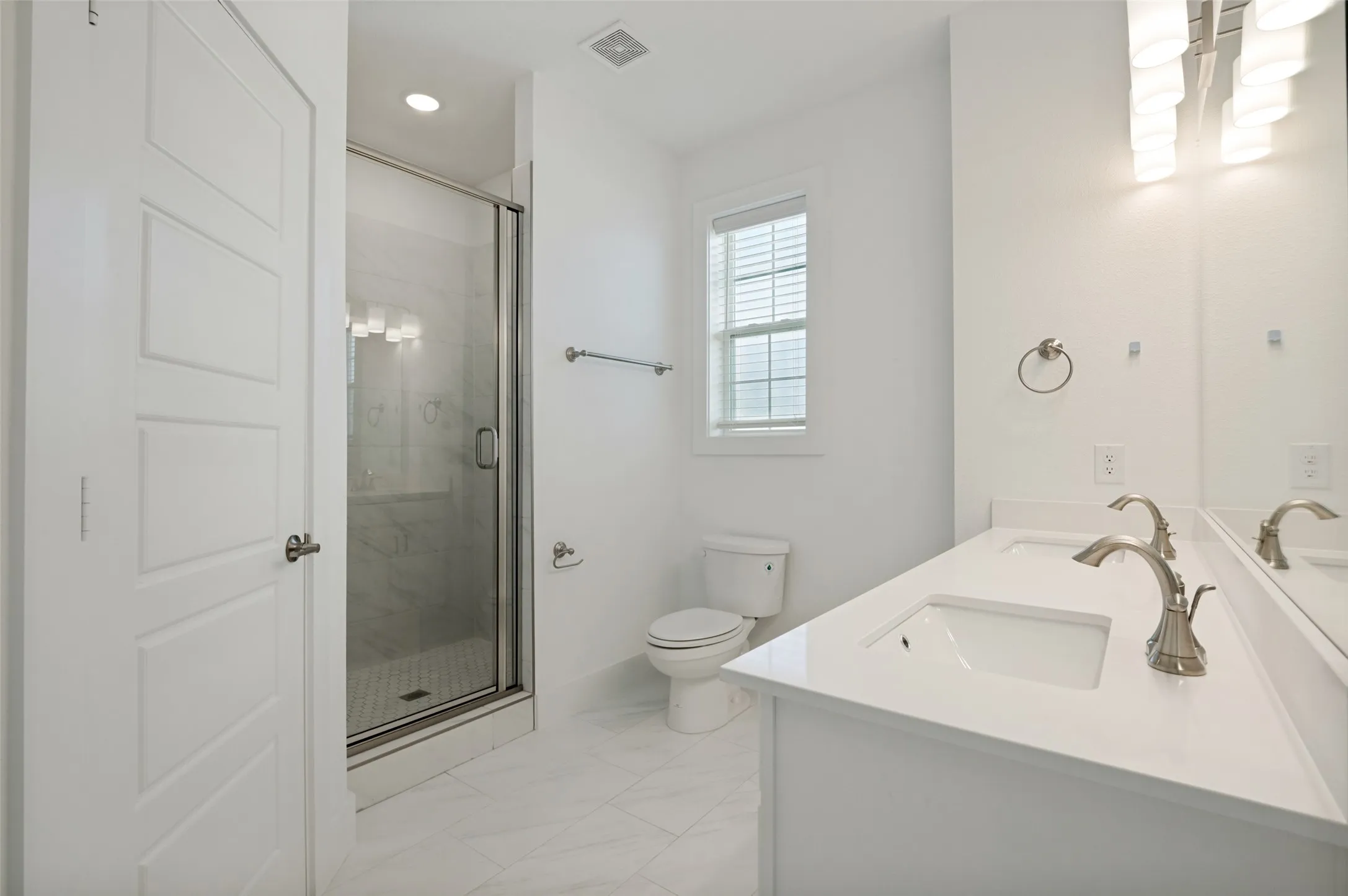 Dual vanity with integrated sinks, brushed nickel fixtures, and ample counter space