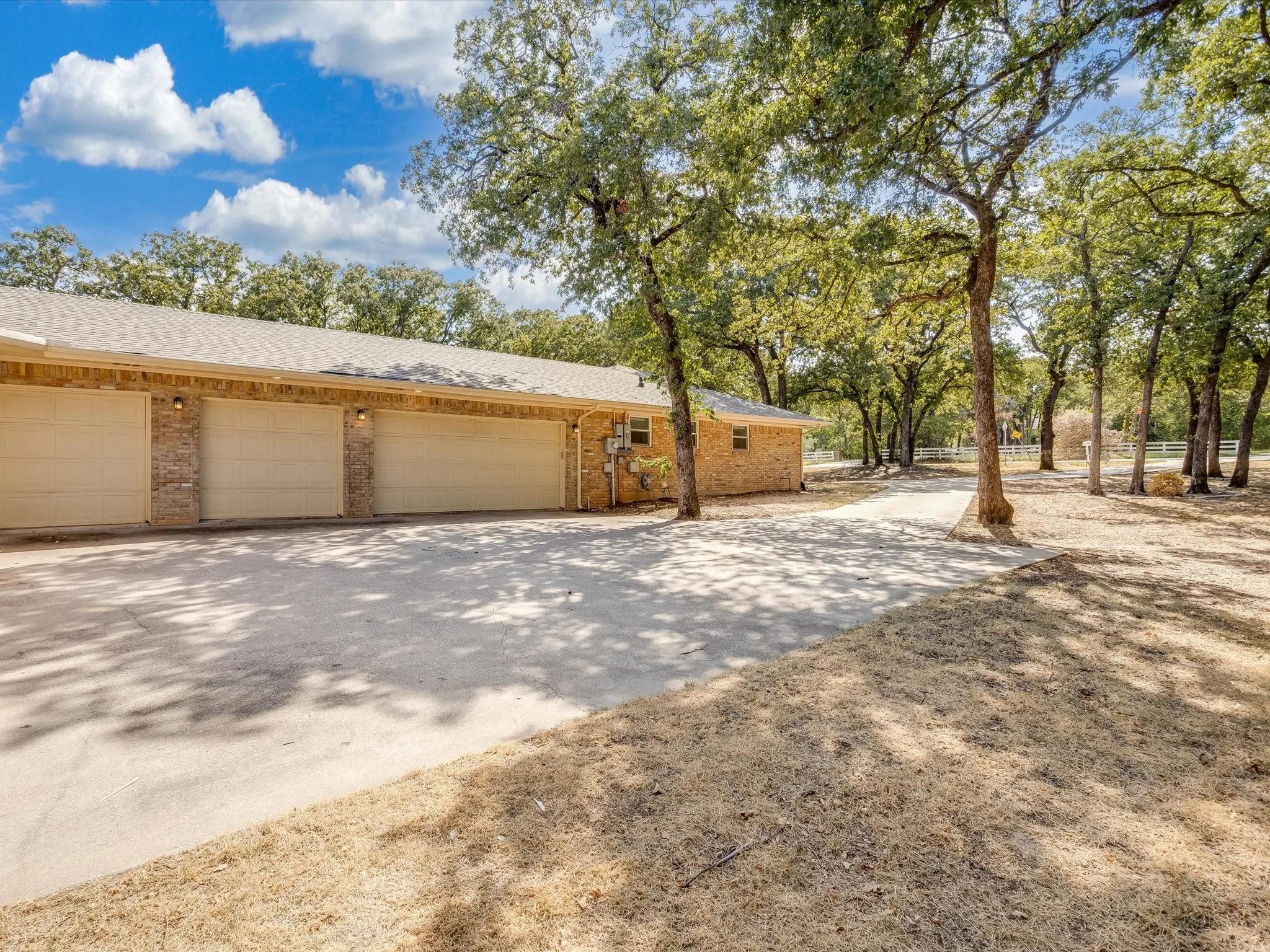 Four car garage with brick veneer siding and concrete driveway