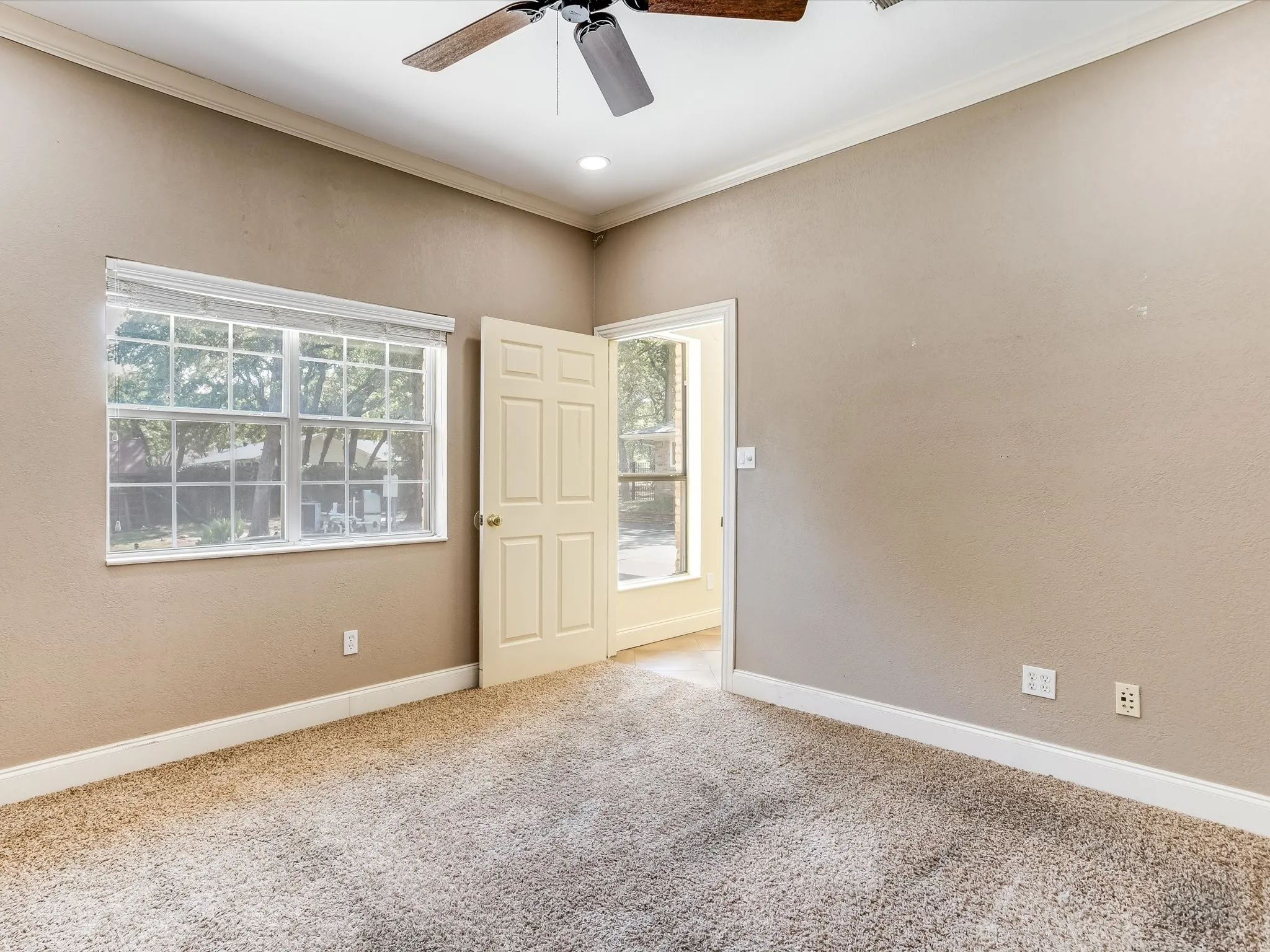 Recessed lighting, crown molding, ceiling fan, carpeted flooring, and a multi-pane window