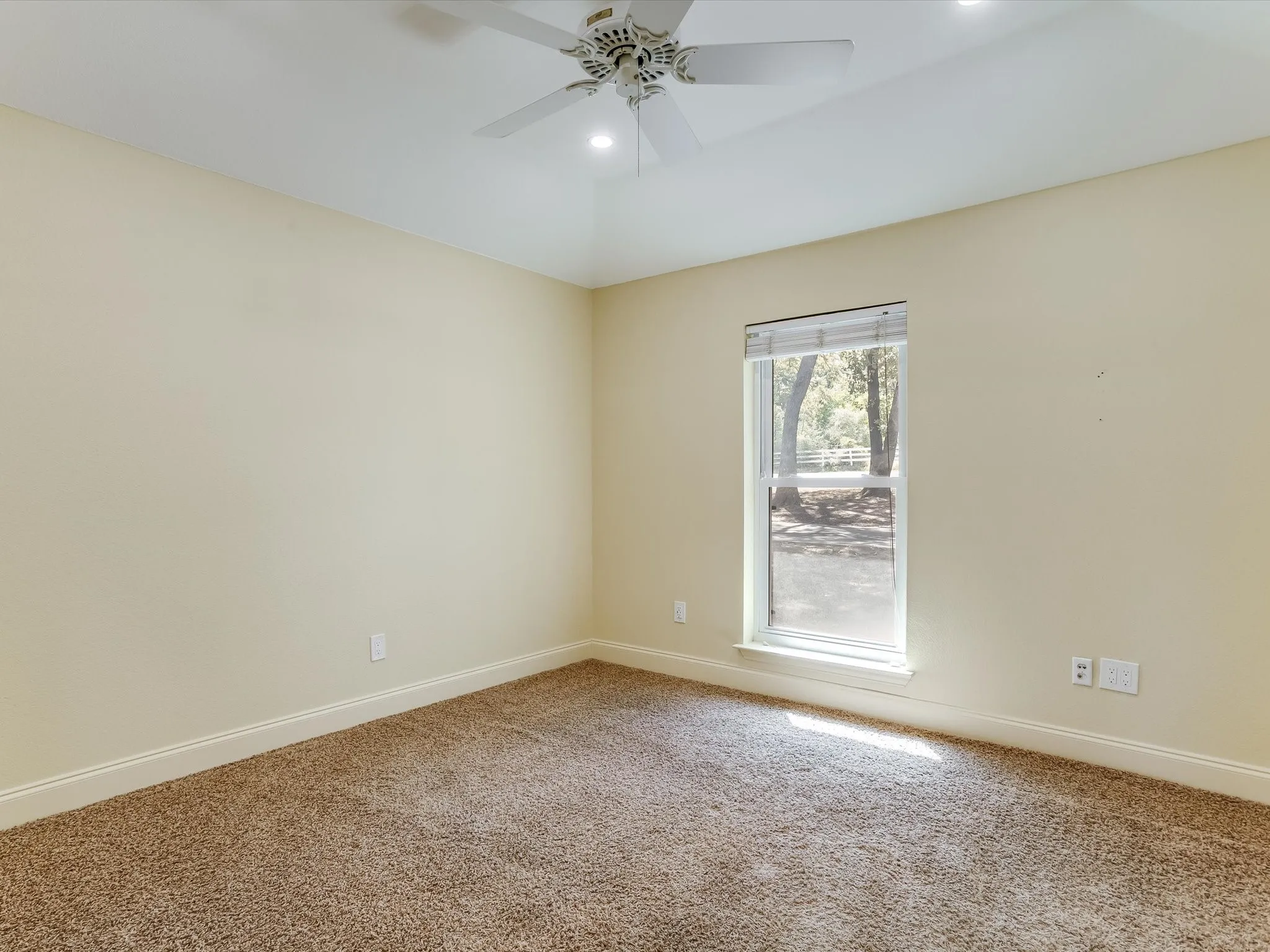Guest room 2. Vaulted ceiling with recessed lighting and a ceiling fan, a window with blinds, and carpeted flooring