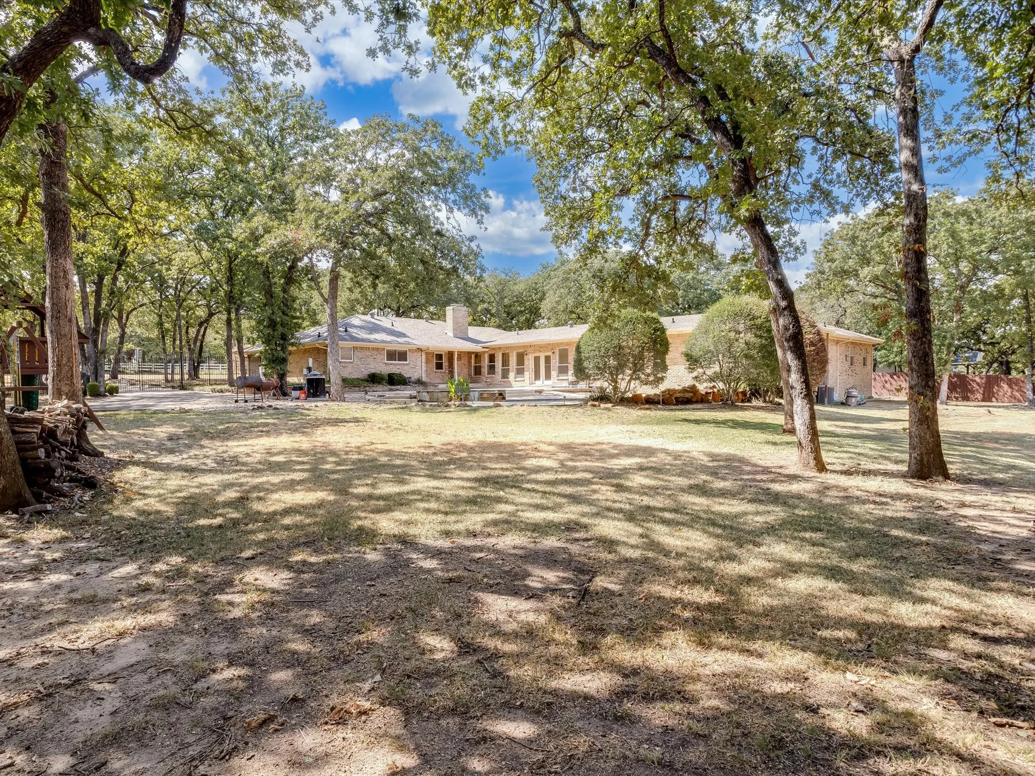 Expansive lawn area surrounded by numerous mature trees