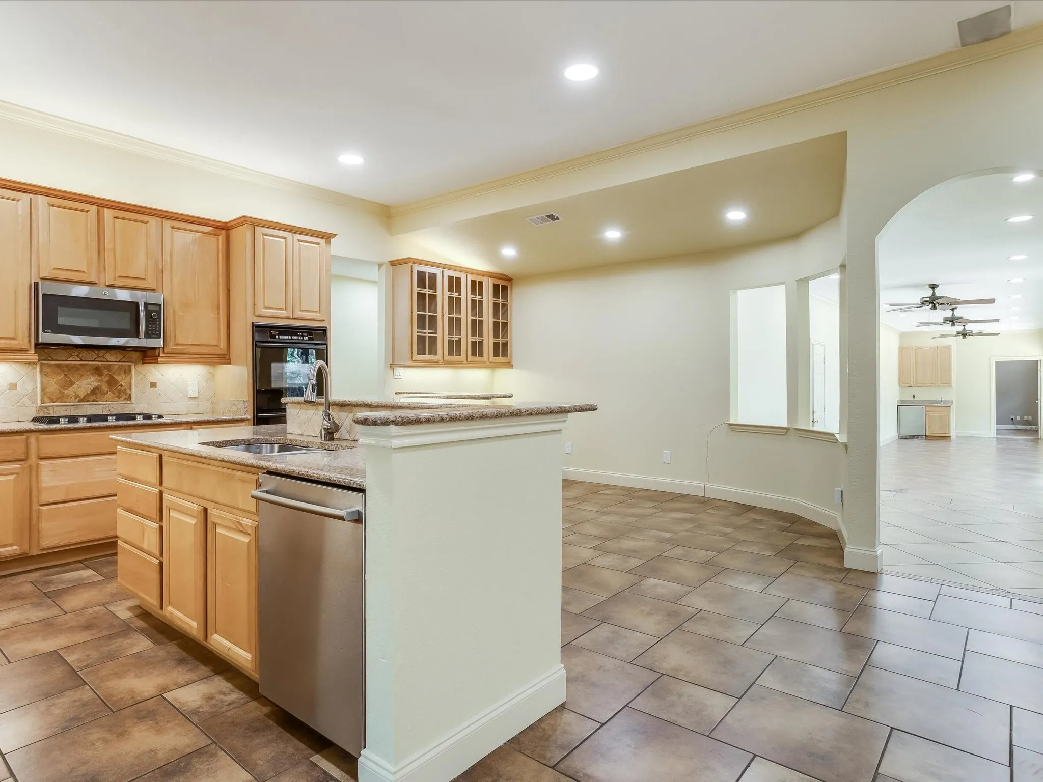 Kitchen featuring wood cabinetry, stainless steel appliances, recessed lighting, and tile flooring