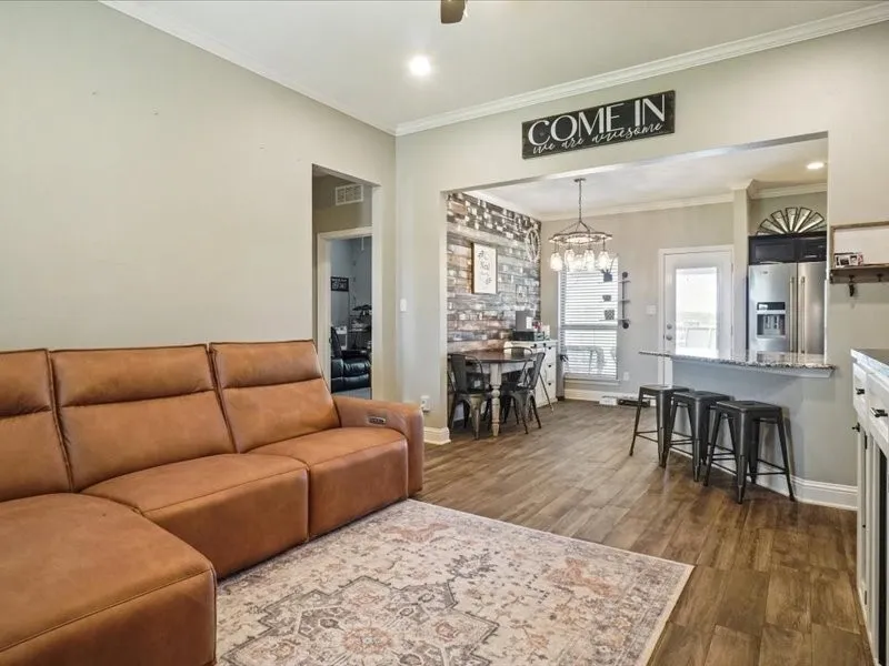 Wood-finish flooring throughout, crown molding, and recessed lighting