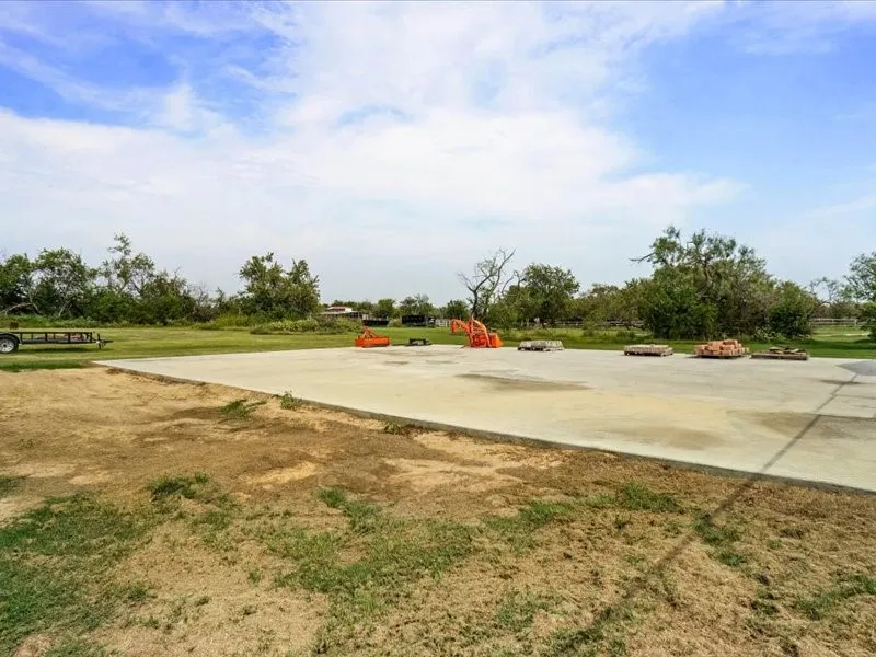 Expansive concrete pad surrounded by a large grassy area