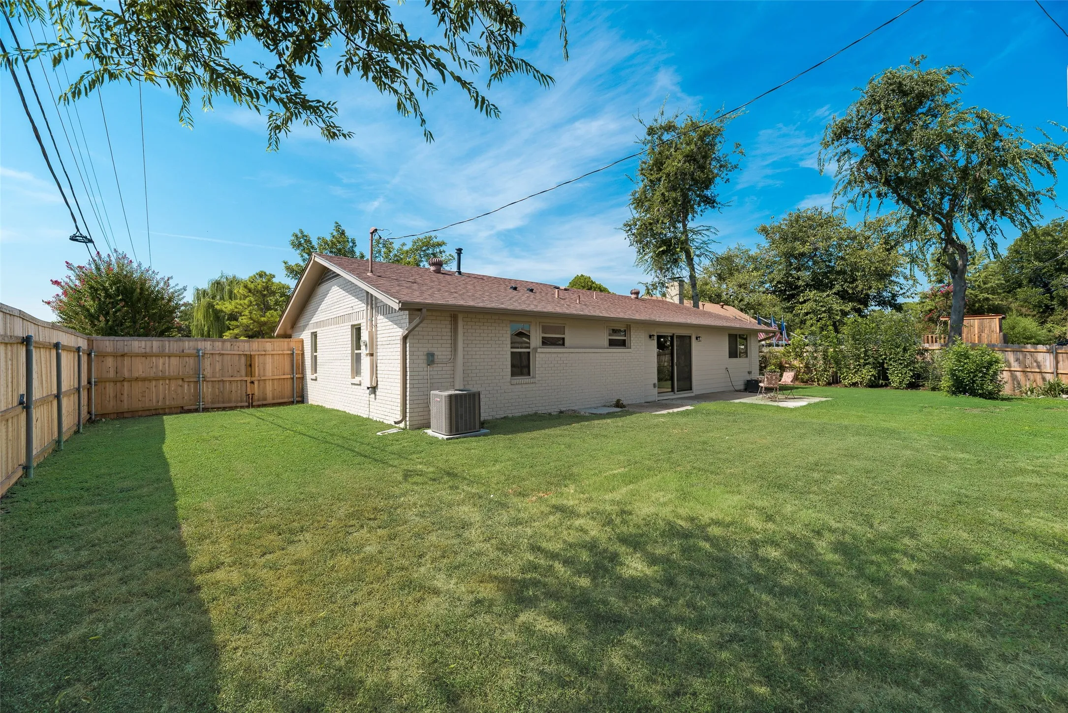 Rear view of property featuring a fenced backyard, brick siding, a patio area,