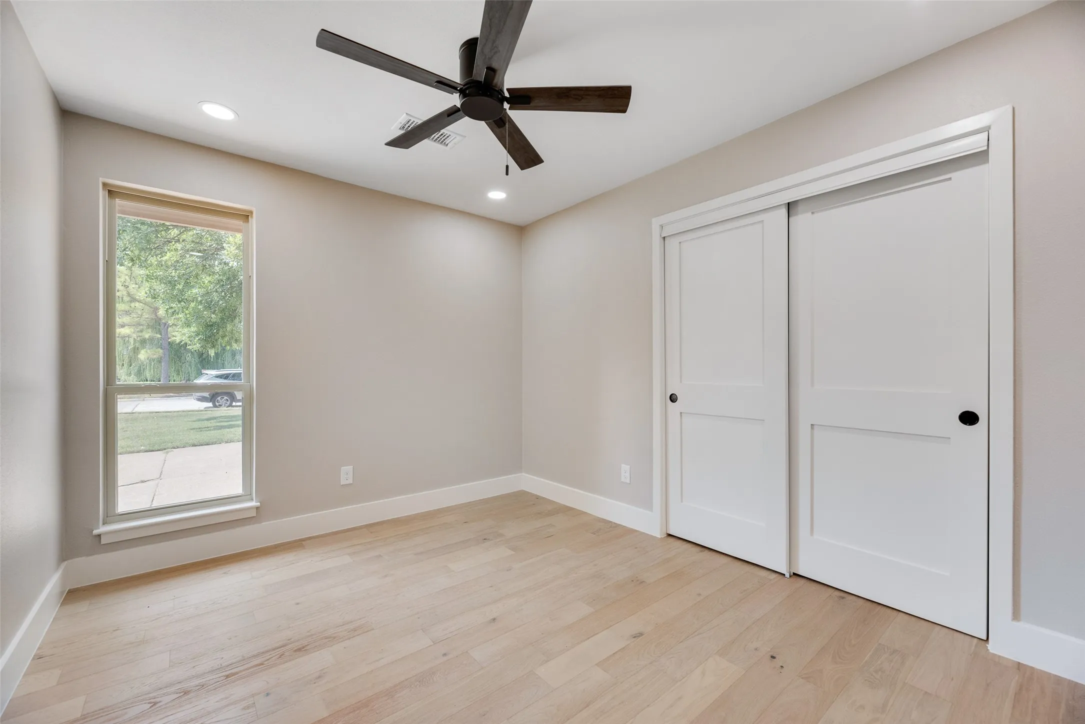 3rd bedroom with light wood finished floors, recessed lighting, ceiling fan, and a closet