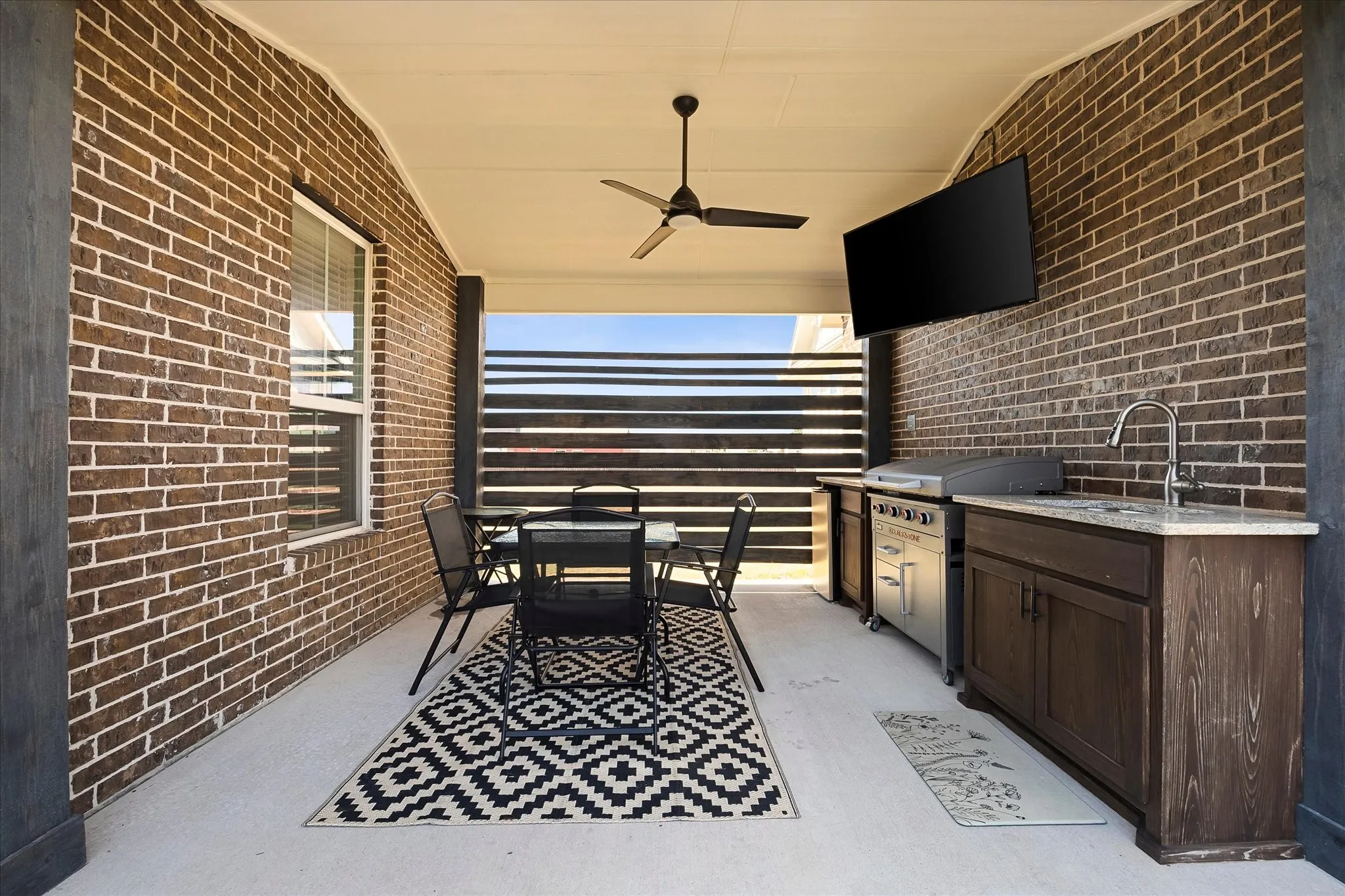 The breezeway patio has an outdoor kitchen setup that brings everyone together to grill and catch the game.
