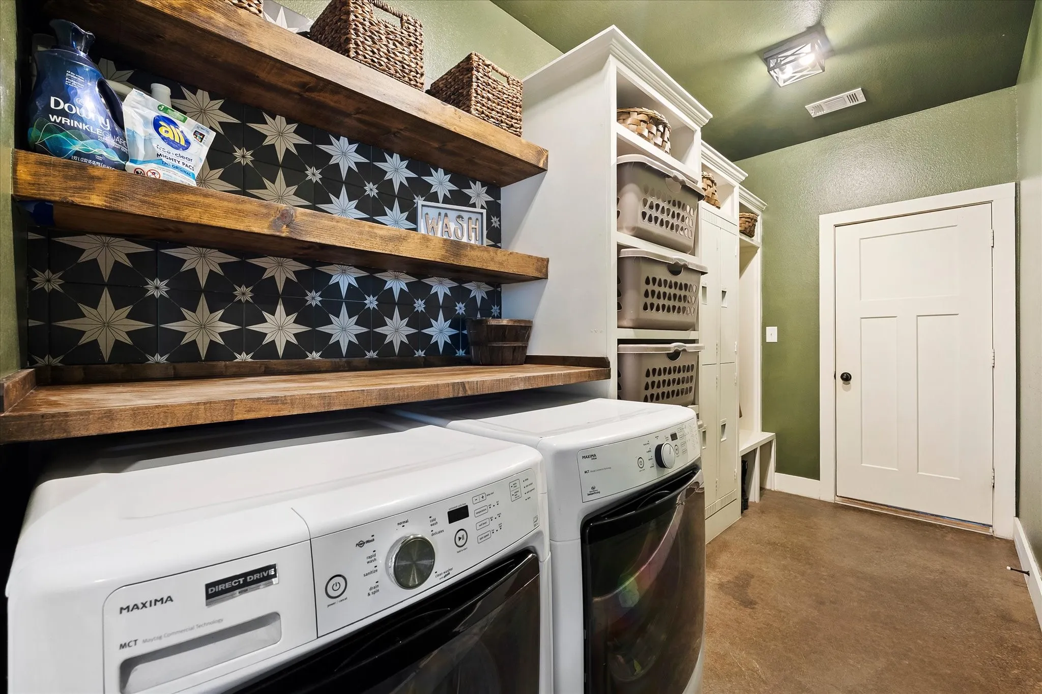 The large laundry room boasts a folding counter, storage cabinetry, fun lockers and mud bench.
