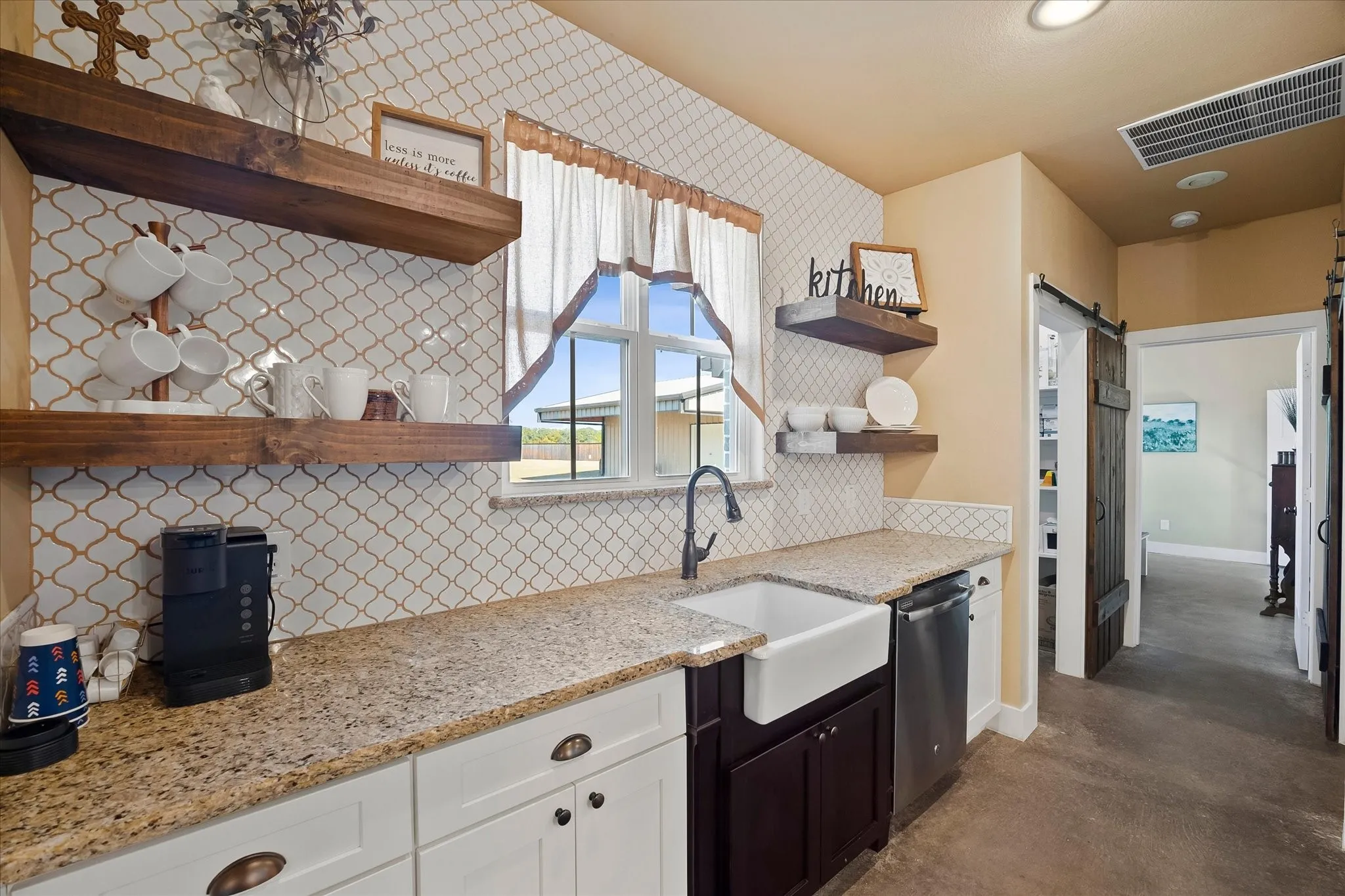 The sunny window over the farm sink allows you to observe backyard activities while washing up. There's also a large walk-in pantry with a barn door.