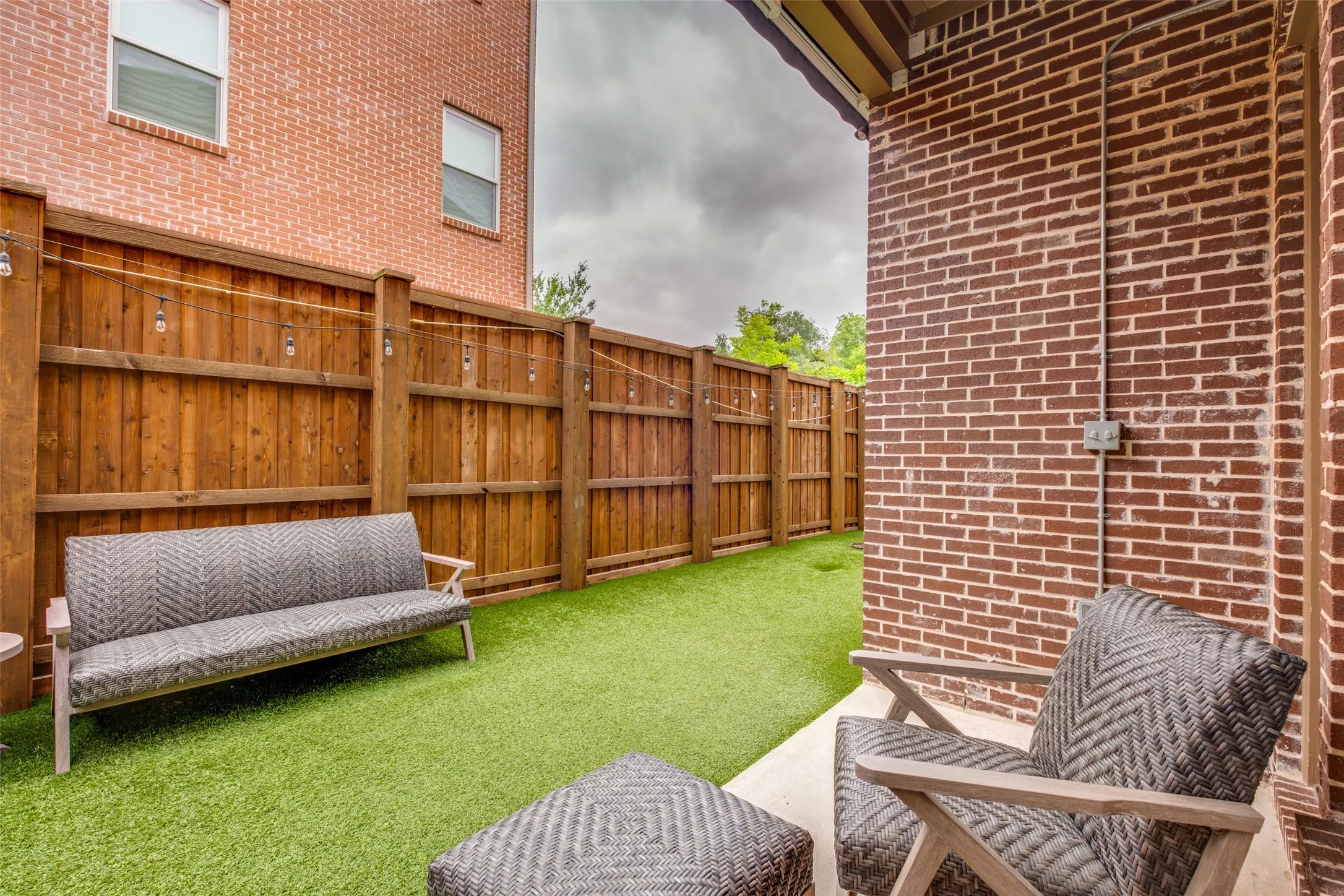 Perfect size yard with artificial turf, decorator lights and covered patio with retractable awning and ceiling fan