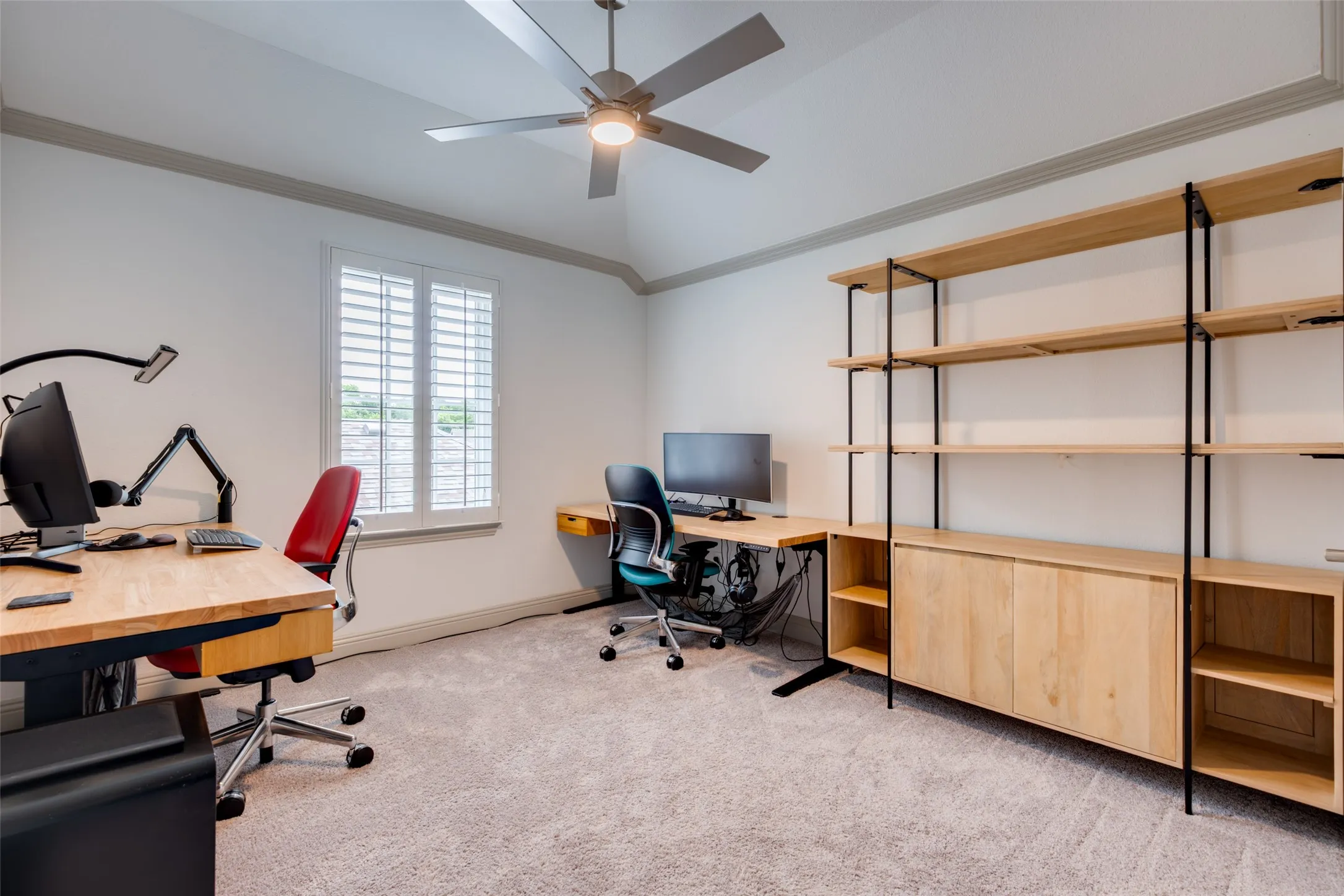 Secondary bedroom used as a study with crown molding and ceiling fan