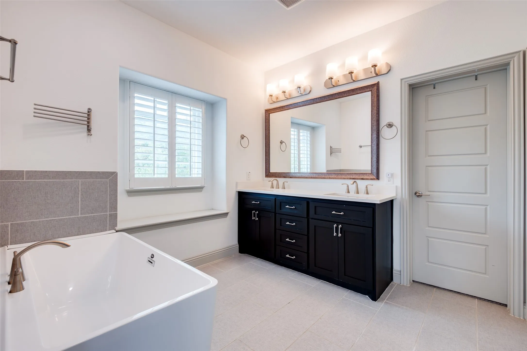Vanity with lots of storage, large framed mirror and decorator lights