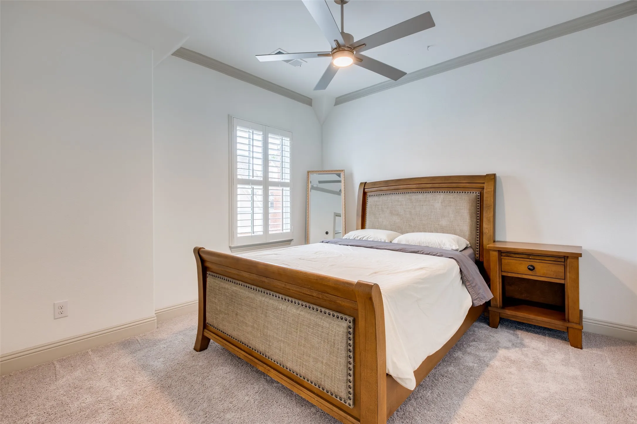 Secondary bedroom with crown molding and ceiling fan