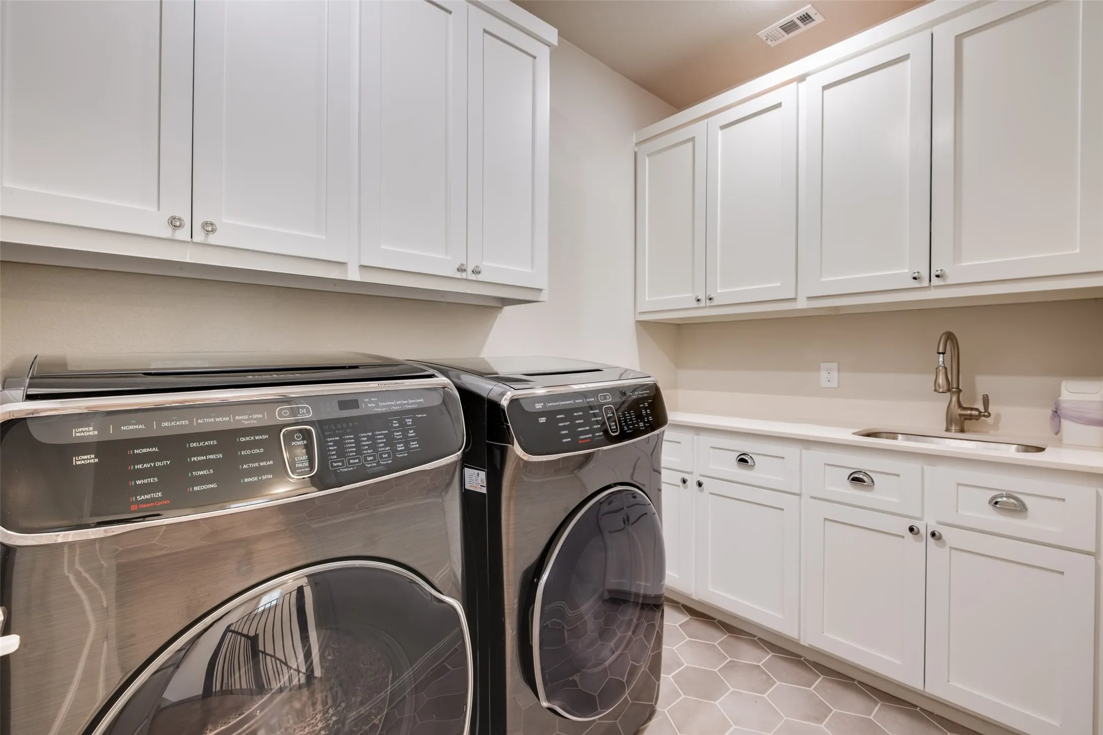 Large laundry room with lots of cabinets and built in sink