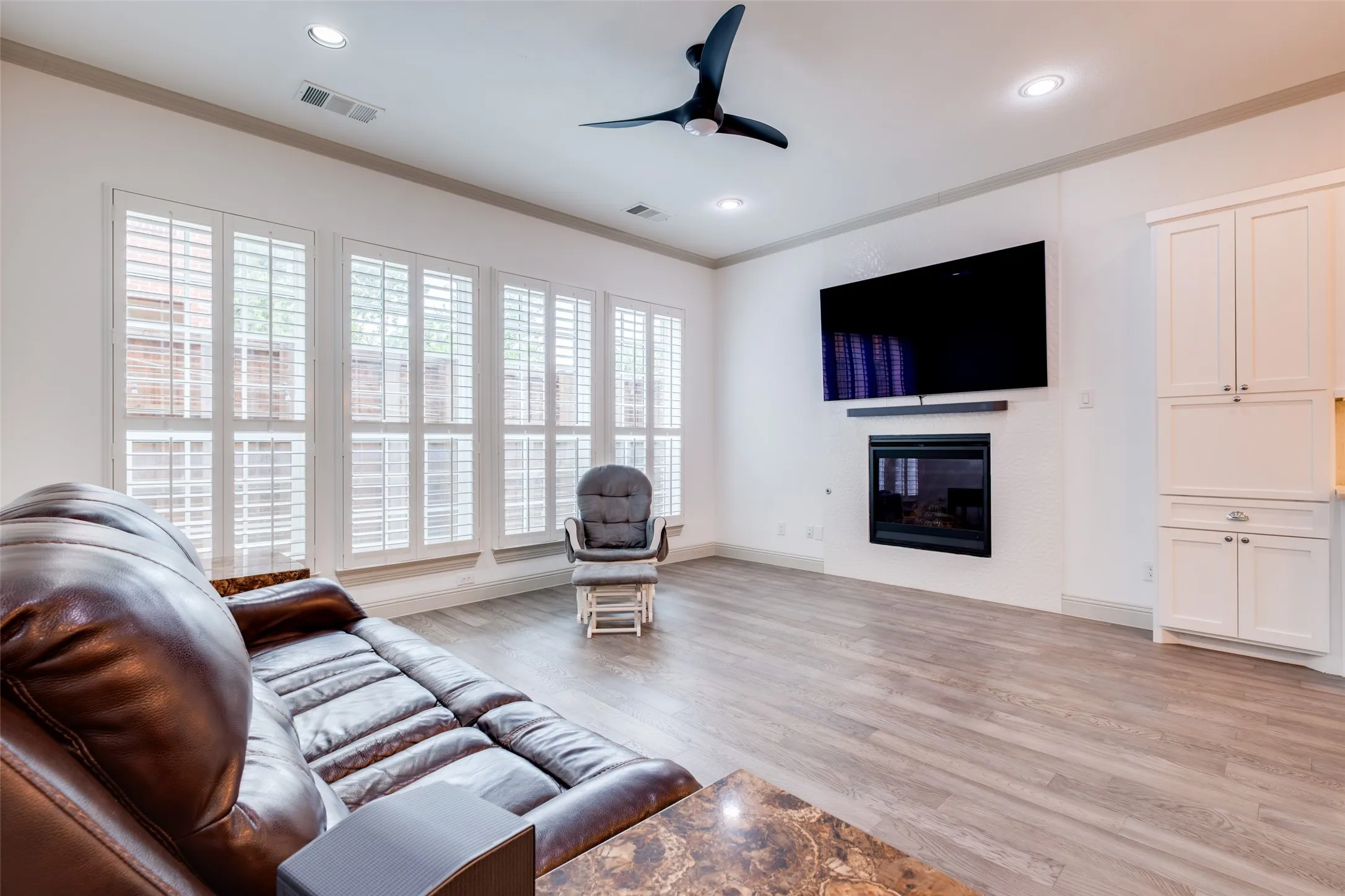 Living room with lots of natural lighting, beautiful continuous wood floors and crown molding