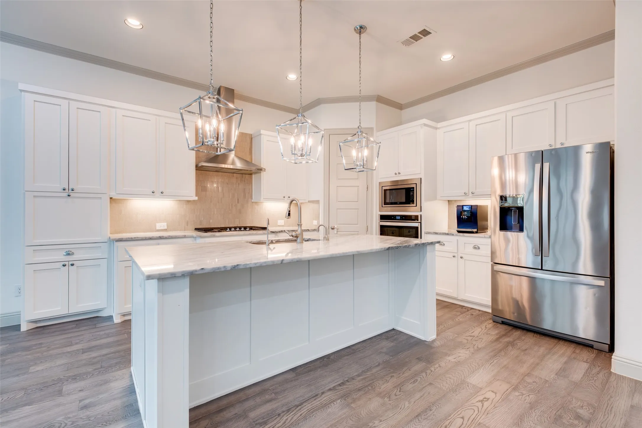 Elegantly appointed kitchen with gas cooktop, built-in oven and microwave and large breakfast island with breakfast bar.