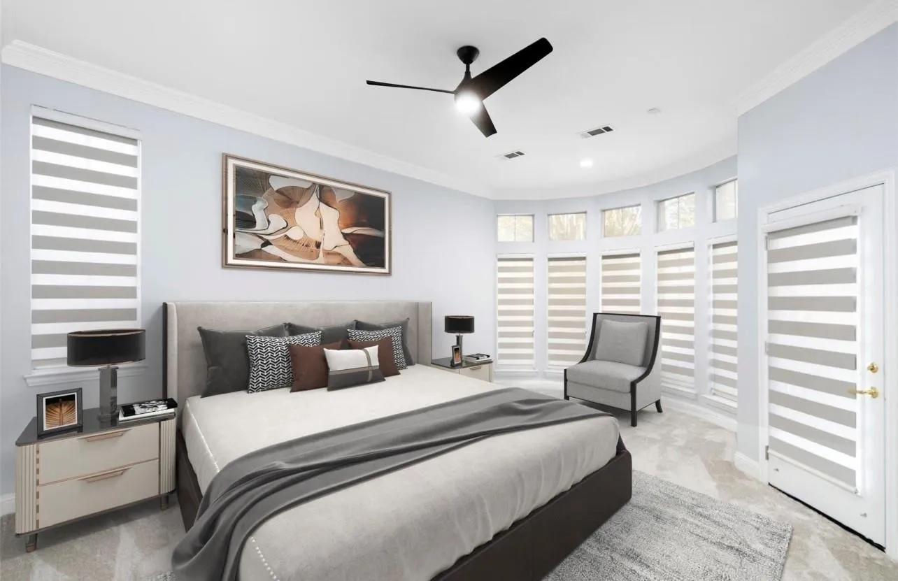 Bay window with multiple panels, crown molding, ceiling fan, carpeted flooring, and a white door with brass hardware