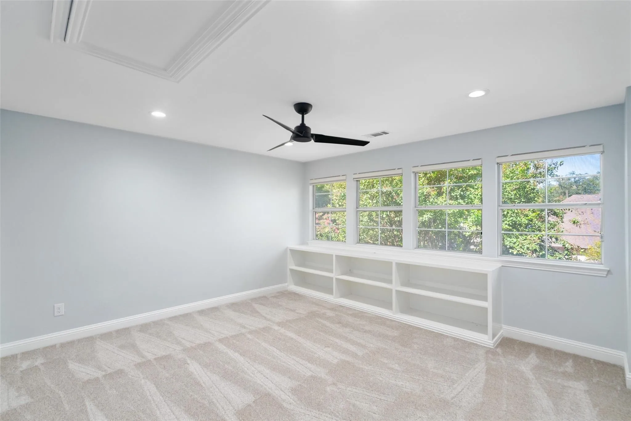 Recessed lighting and ceiling fan complement plush carpeting