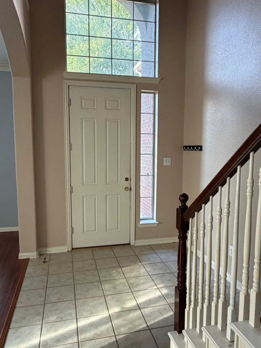 Two-story entryway with a transom window and sidelight, featuring a full-light door