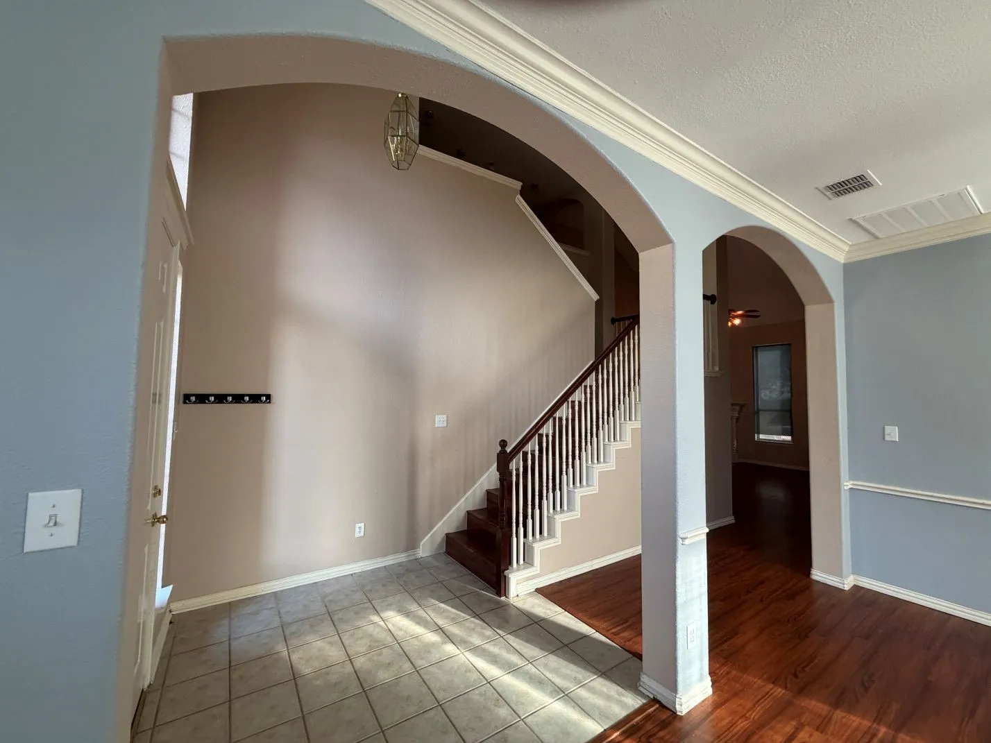 Arched doorways, crown molding, and wood-finish flooring