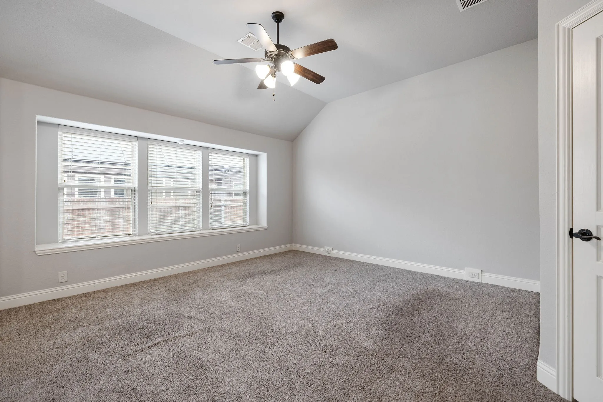 Spare room with lofted ceiling, carpet floors, and ceiling fan