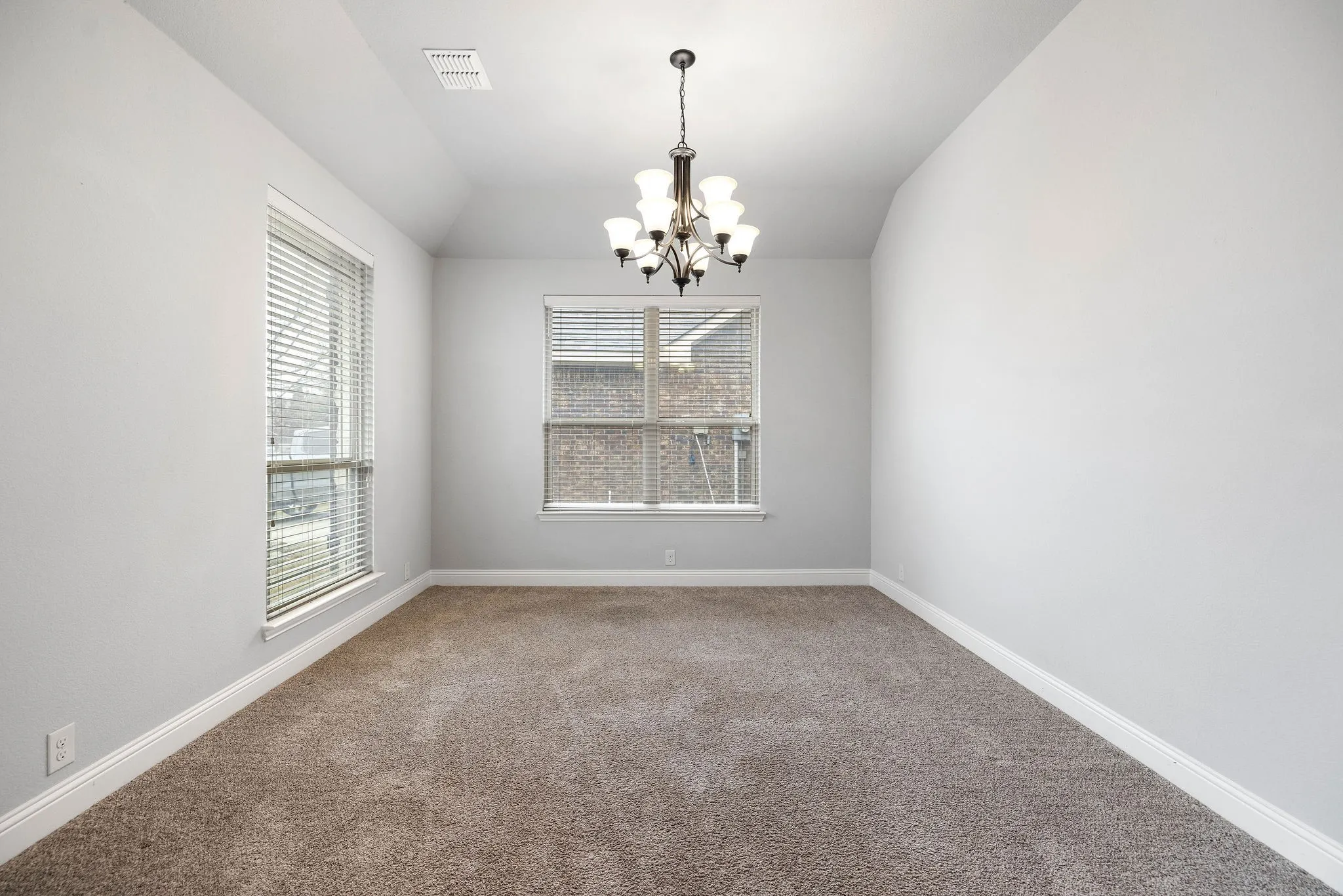 Front flex room featuring lofted ceiling, a chandelier, and carpet flooring