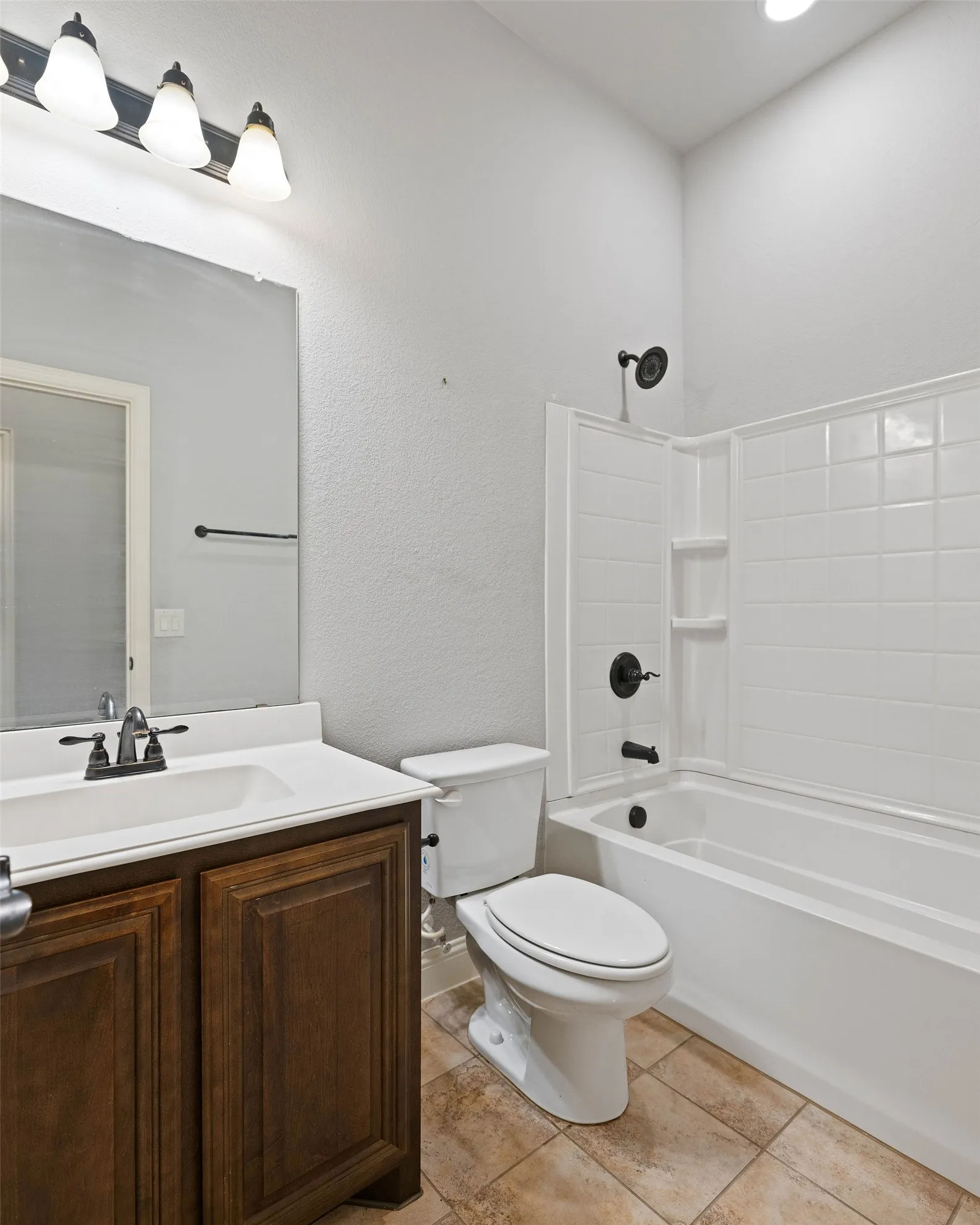 Full bathroom with vanity, tile patterned flooring,  shower combination, and toilet