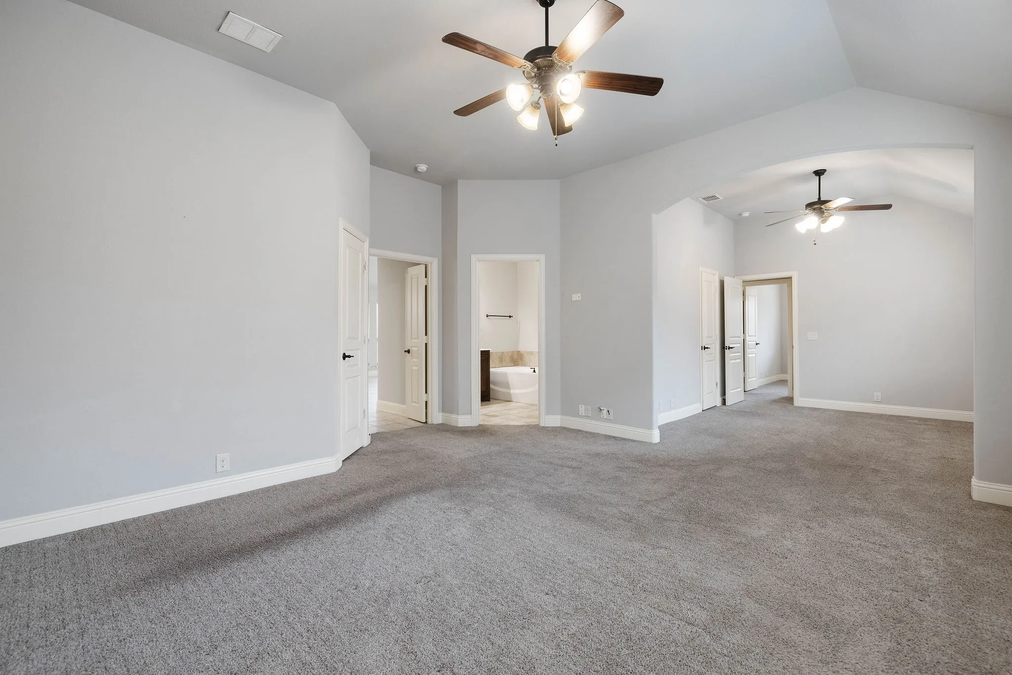 Carpeted empty Primary bedroom featuring ceiling fan and lofted ceiling, you can also see the extra space for workout equipment, or office, or strategically add a wall for another room