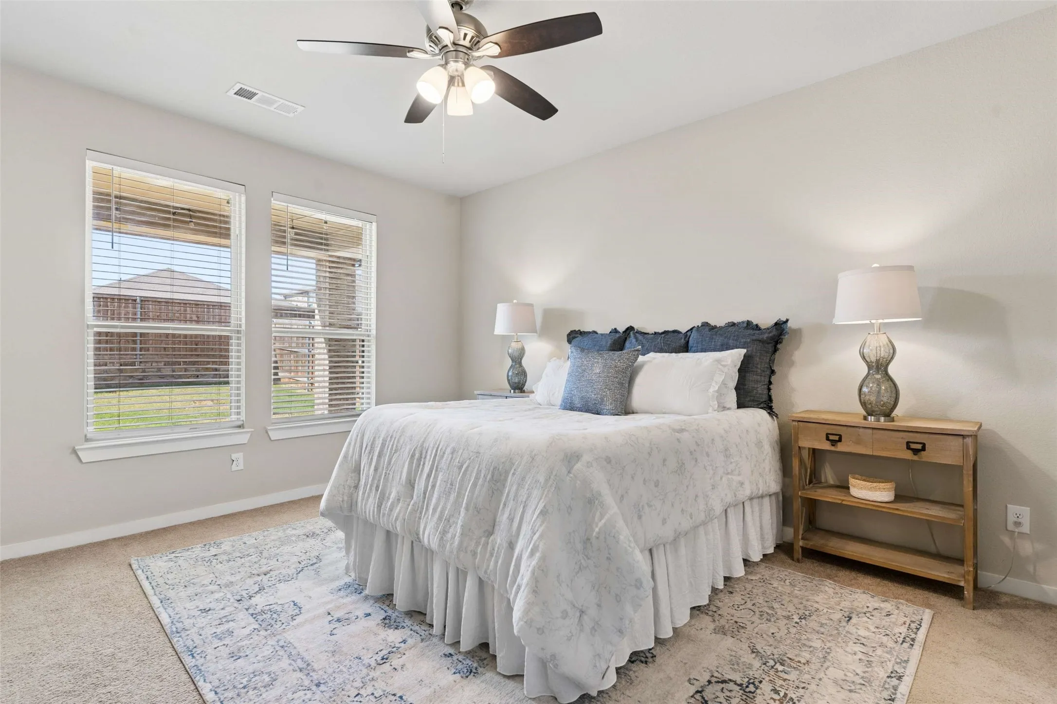 Carpeted room with neutral wall tones and a ceiling fan