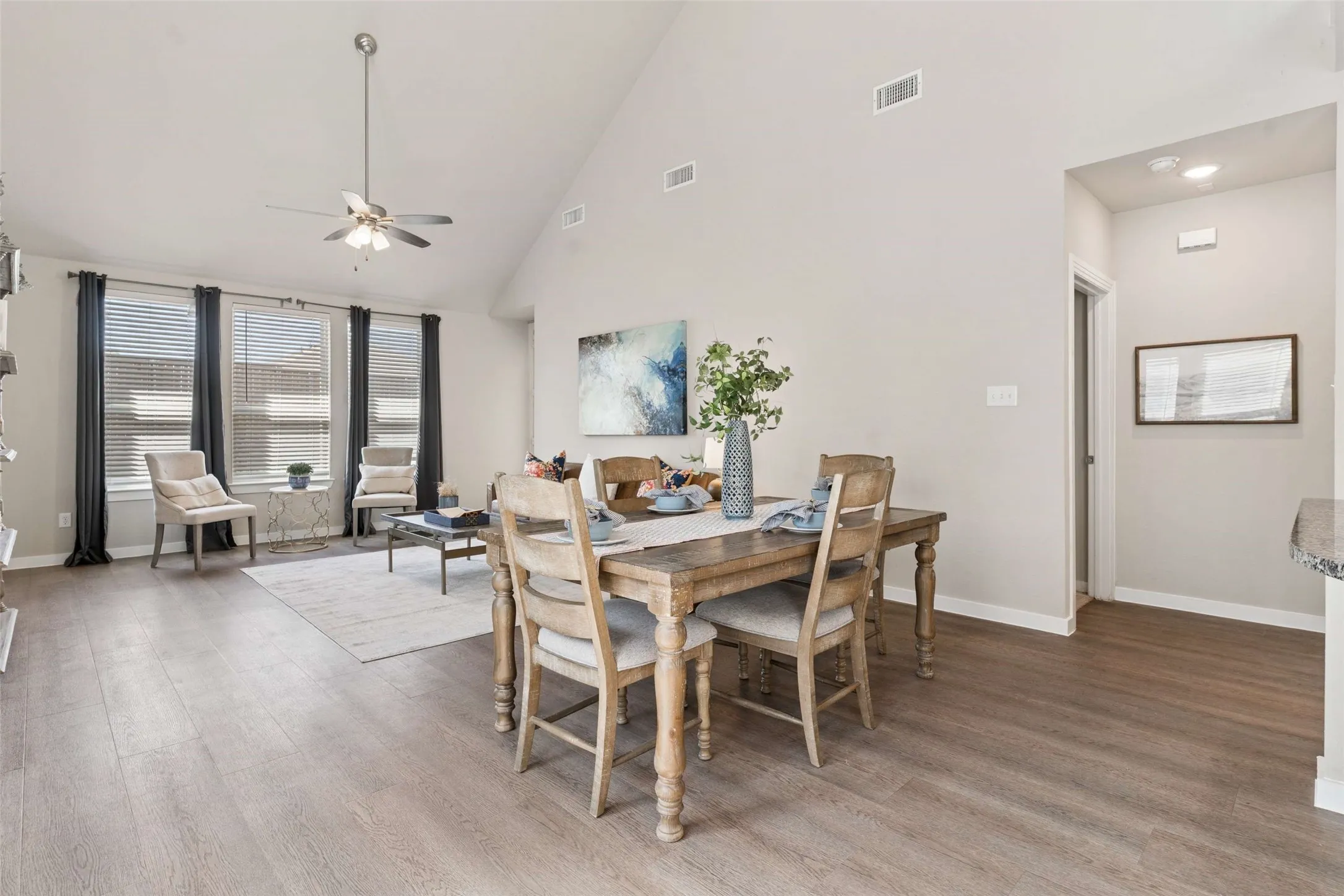 Vaulted ceilings, wood-finish flooring, and a ceiling fan with integrated lighting